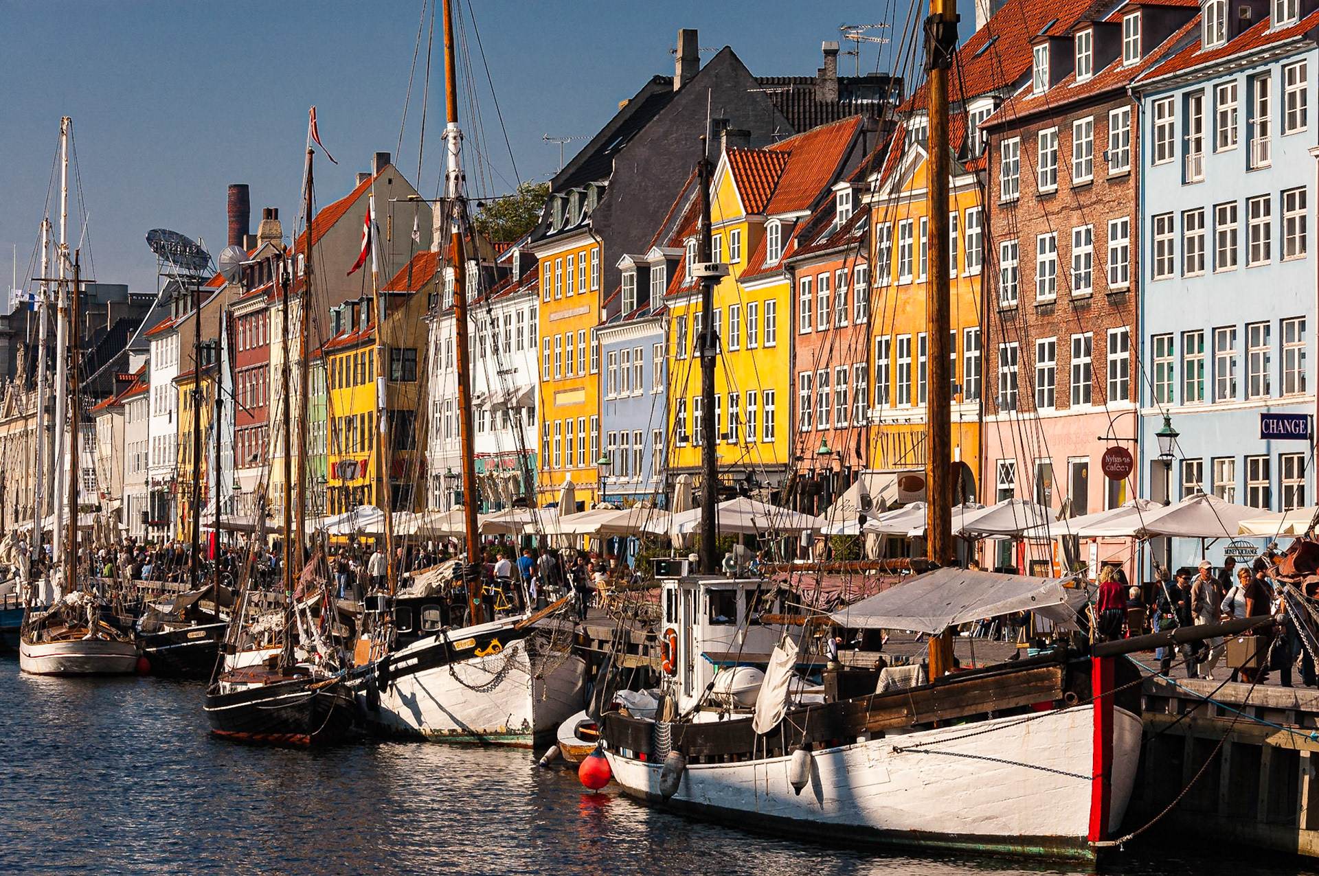 The mood of this view of Nyhavn from the Holbergsgade-Toldbodgode bridge is extremely busy, with colorful buildings, strolling people, and criss-crossing masts and sall lines, just as the sidewalks were that sunny day.Date: 24 September 2007Location: København (Copenhagen), Hovedstaden, Danmark (Denmark)Original resolution: 6 MPProcessing: Processed from RAW using Adobe Photoshop Lightroom CC 2015