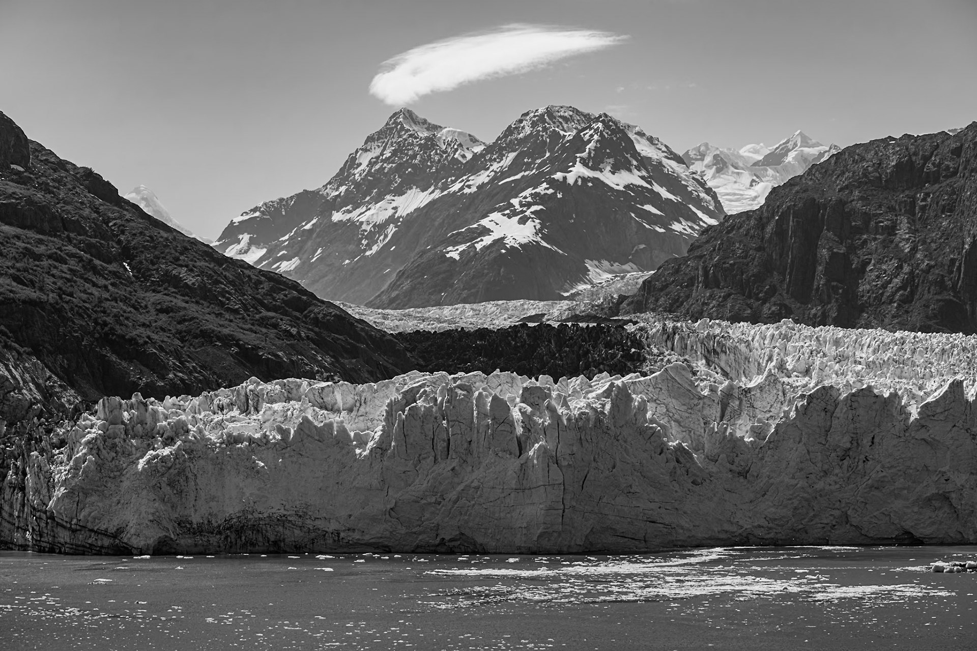 Our cruise ship spent the Fourth of July in Glacier Bay National Park and Preserve. Once we arrived at the end of the Tarr Inlet, the ship did a slow rotation so that all sides could see the various glaciers. I decided that I liked this photo of the Margerie Glacier best in black-and-white.As best I can tell, that's Mount Tlinget with the cirrus clouds forming above it as the winds pass over the peak.Date: 4 July 2022Location: Glacier Bay National Park, Alaska, United StatesOriginal resolution: 45 MPProcessing: Processed from RAW using Adobe Photoshop Lightroom Classic 12