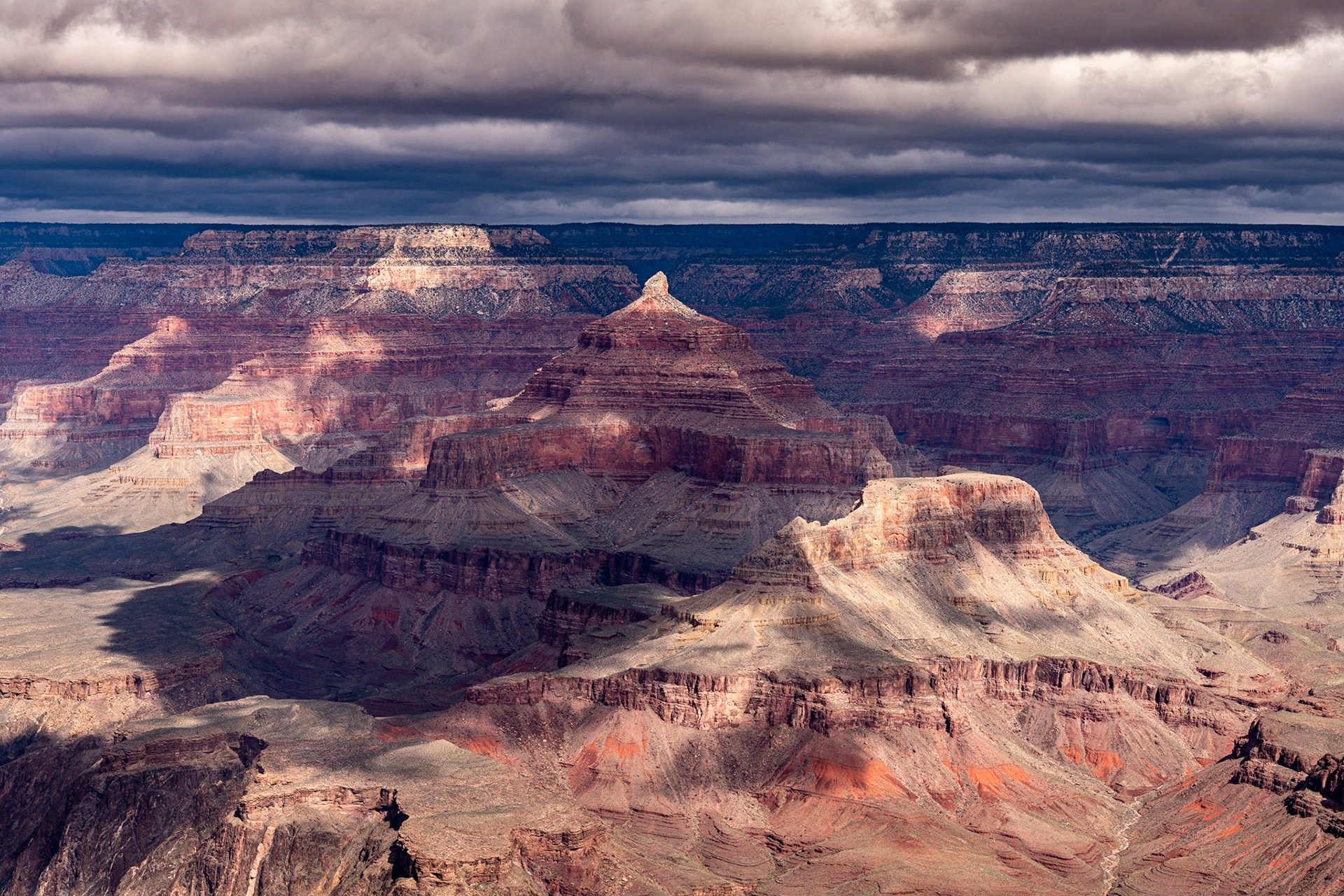 On our last day at Grand Canyon, we went back to Mather's Point one last time to look out at the canyon. The skies at mid-morning were a mix of snow clouds to the north and sunlight on the South Rim.I noticed that the peak of Isis Temple was passing in and out of sunlight and waited to take this shot when the peak was highlighted.Distances in the canyon are deceptive. In this case, Isis Temple sits about five miles away from where I took the photo.Date: 18 March 2020Location: Grand Canyon National Park, Arizona, United StatesOriginal resolution: 45 MPProcessing: Processed from RAW using Adobe Photoshop Lightroom Classic 9