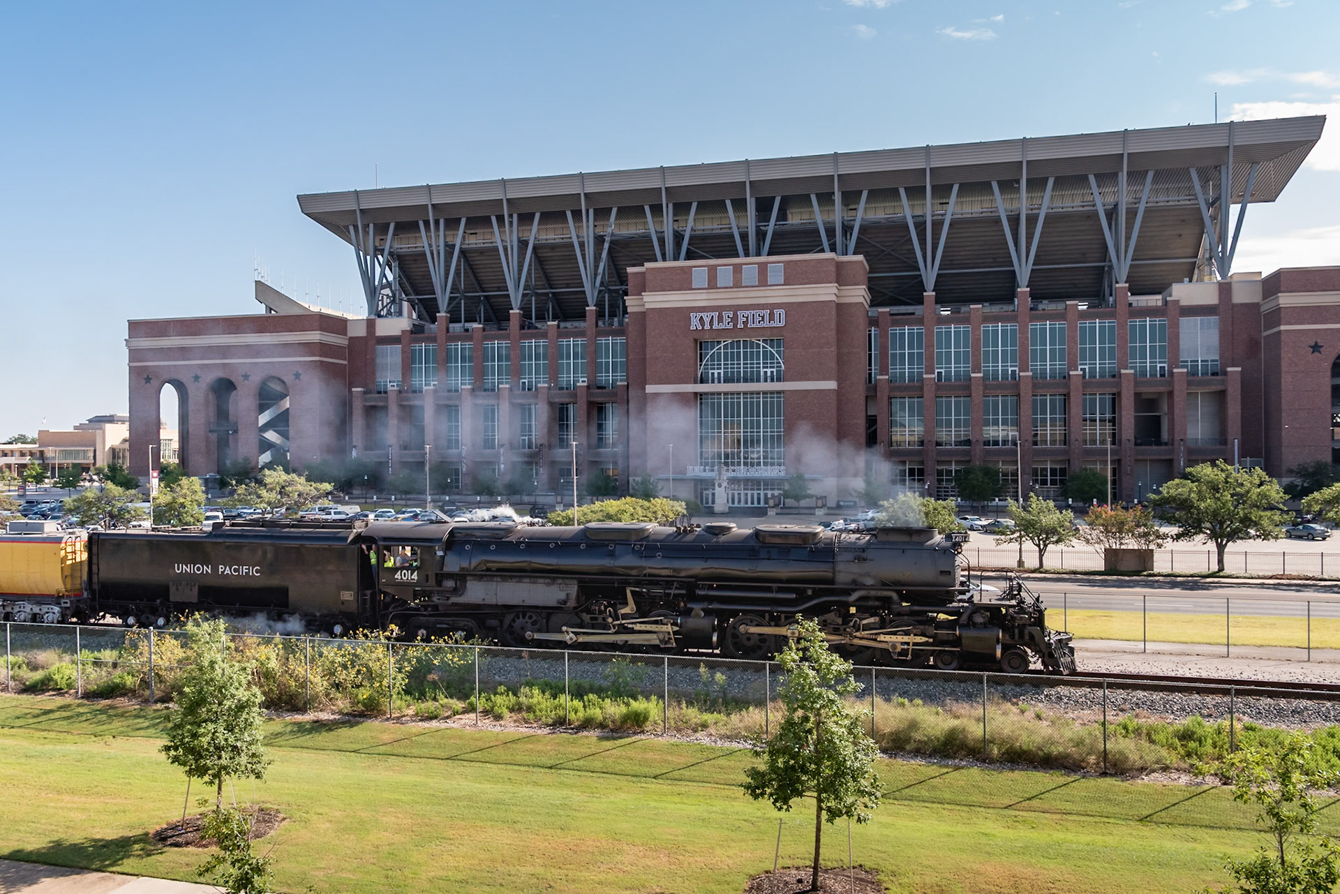 I knew Union Pacific 4014, the Big Boy, would pass by Texas A&amp;M University on its way from Hearne to Hemphil and then on to Houston. I knew the tracks ran by Kyle Field, so I wondered if there was a good location to photograph both the locomotive and the stadium. It turns out that the Student Recreation Center across the street has a nice pavillion overlooking the stadium, and by coincidence, the railroad tracks.According to a UP engineer who was taking photos on the pavillion, the folks waving from the cab are the Mayor of College Station and his wife.Date: 16 August 2021Location: College Station, Texas, United StatesOriginal resolution: 36 MPProcessing: Processed from RAW using Adobe Photoshop Lightroom Classic 10
