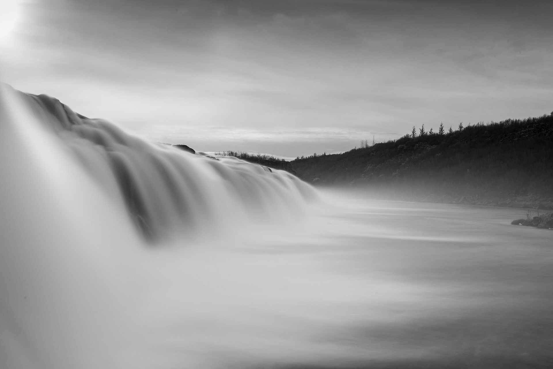 Faxafoss is a long fall of modest height on the Tungufljót River. I was able to walk up to the edge of the falls and shoot along their length. I liked this angle best. The sun provides some directional lighting from the upper left. The cloudy sky and diffused sunlight made the photo relatively monochromatic, so I processed this image as black and white.Date: 17 October 2017Location: IcelandOriginal resolution: 36 MPProcessing: Processed from RAW using Adobe Photoshop Lightroom 6