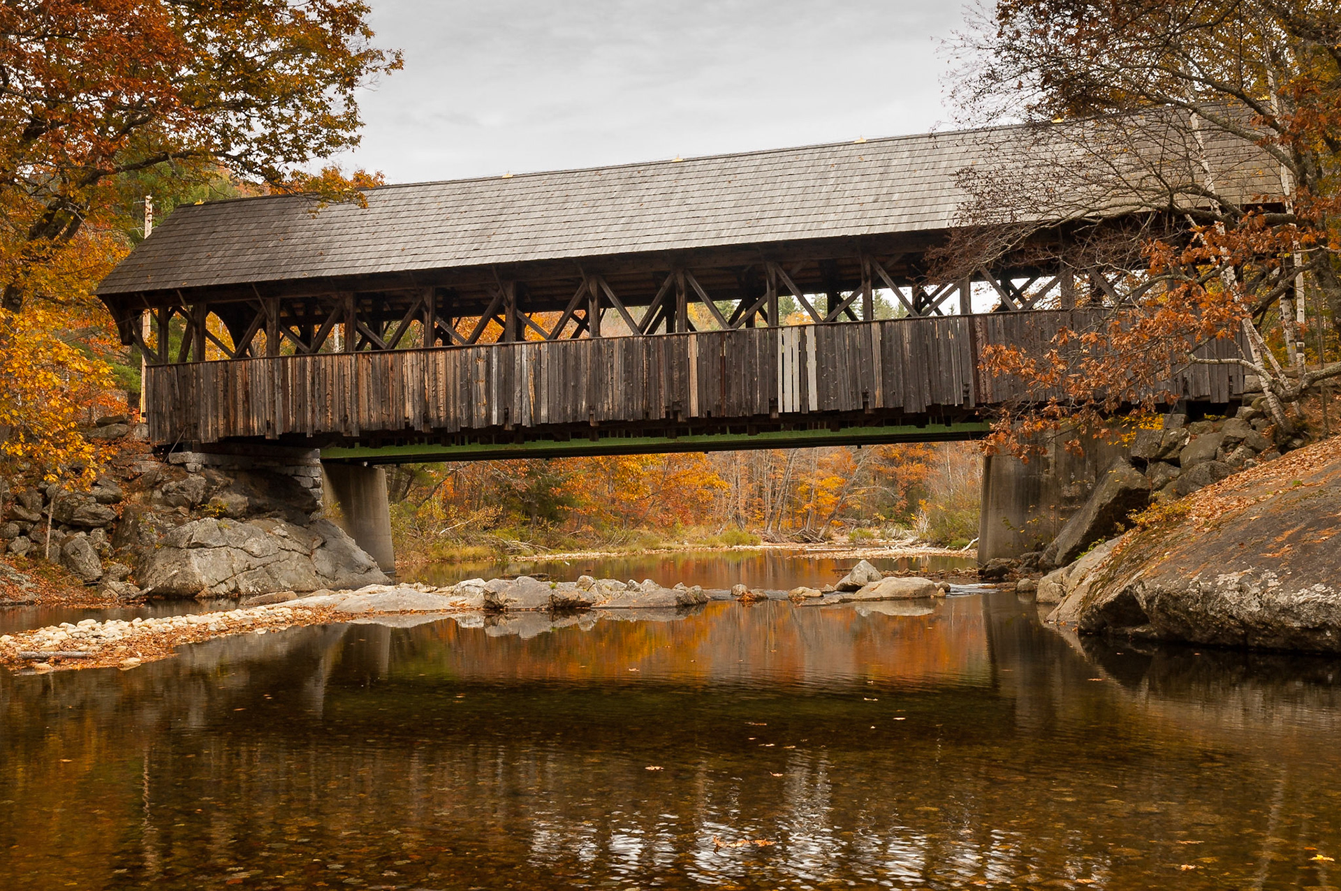 The Sunday River bridge, built in 1872, is also named the Artist's Bridge because of its reputation as being the most photographed and painted of the venerable covered bridges in Maine. The bridge, an 87 foot Paddleford truss, was closed to traffic in 1958 when a new bridge was built downstream.The view is from the west side of the bridge, looking east.Date: 10 October 2006Location: Newry, Maine, United StatesOriginal resolution: 6 MPProcessing: Processed from RAW using Adobe Photoshop Lightroom 6
