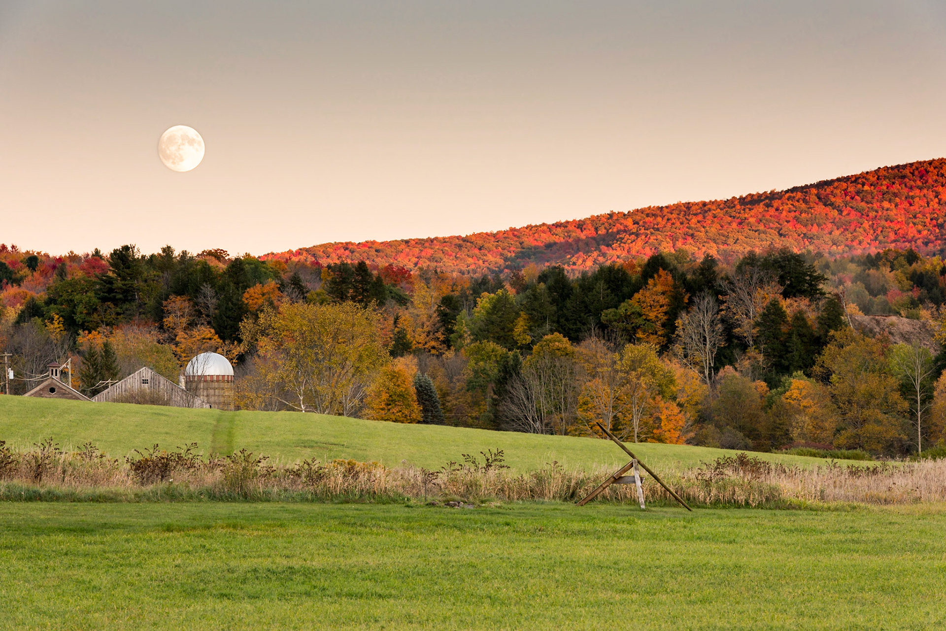 We were out driving in search of Manor Kill Falls in the Catskills and basically went right on past them out Potter Mountain Road. With the sun fading fast, we drove back to a wide spot in the valley surrounding Manor Kill. After shooting a number of photos perpendicular to the sun, I turned to my left and was surprised to see that the moon had risen. The moon looks full in the photo, but in fact it was still waxing and would be a supermoon two days later.Date: 14 October 2016Location: Conesville, New York, United StatesOriginal resolution: 36 MPProcessing: Processed from RAW using Adobe Photoshop Lightroom CC 2015