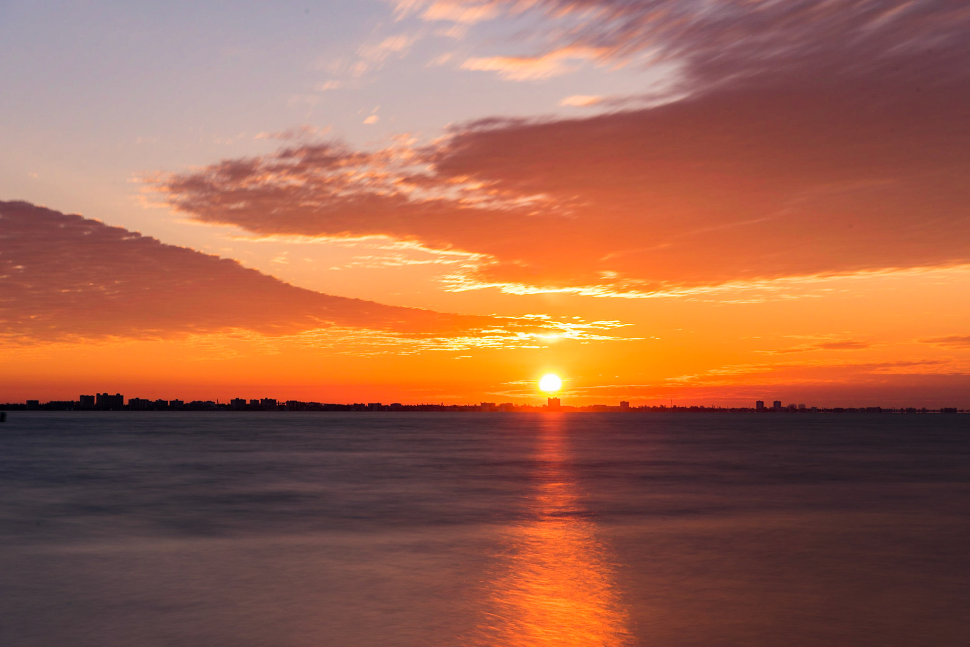 I was at Lighthouse Beach Park on Sanibel Island for sunrise and caught the sun coming up over a condo on Fort Myers Beach, which sits across San Carlos Bay from the island. I used a 3-stop neutral density filter to smooth the water. | 14 March 2018 | Sanibel Island, Florida, United States | 36 MP | Processed from RAW using Adobe Photoshop Lightroom 6