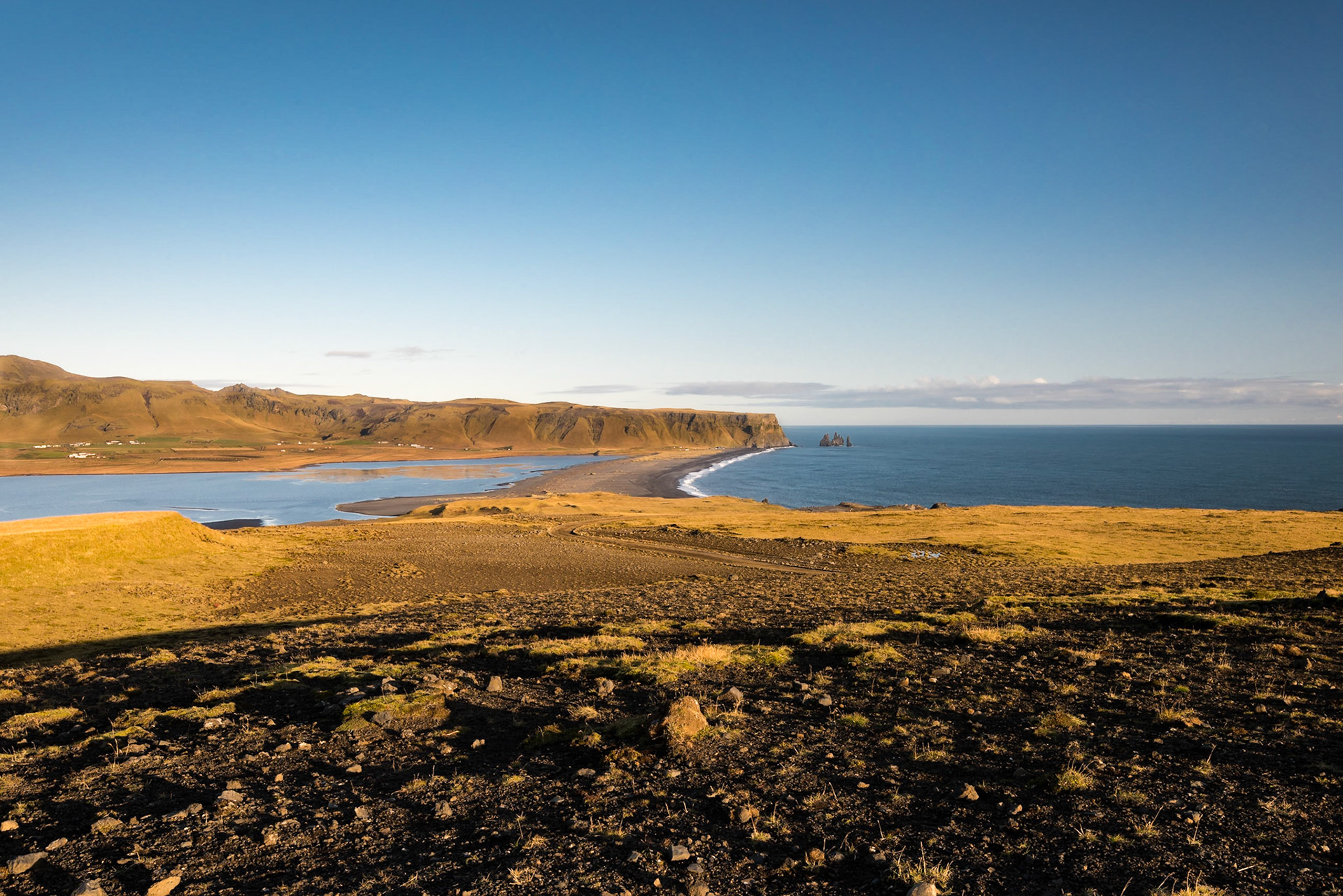 We were on the table rock peninsula of Dyrhólaey late in the afternoon, taking in various views of the countryside and Reynisfjara beach. The ground here arcs downhill in a deceiving fashion so that shadows from the rocks and grass are exagerated.Date: 16 October 2016Location: Vik, IcelandOriginal resolution: 36 MPProcessing: Processed from RAW using Adobe Photoshop Lightroom 6