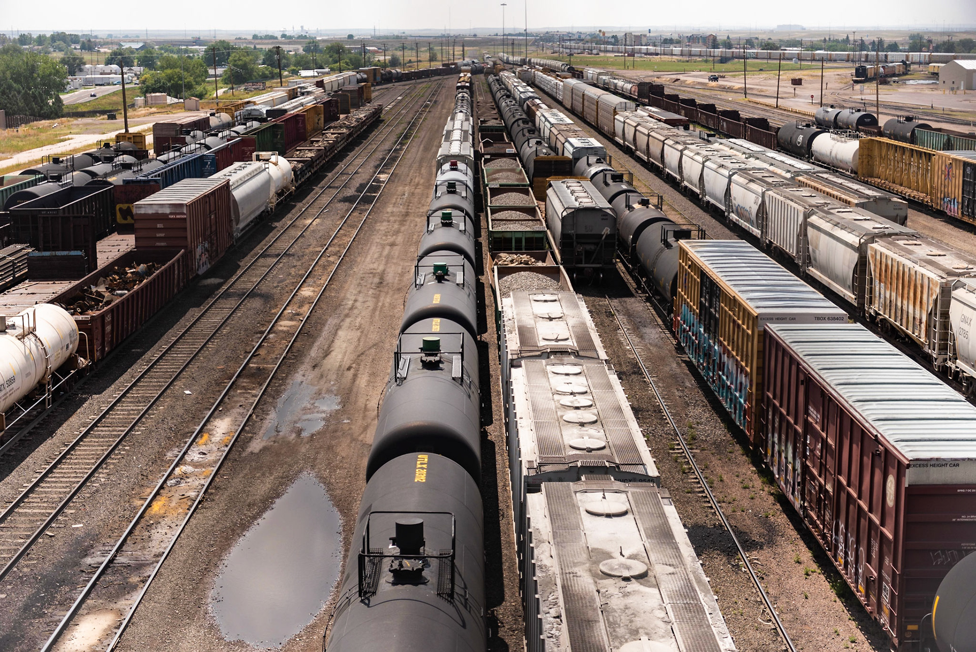 We had stopped at the old Union Pacific depot in Cheyenne and saw the I-180 bridge over the yard. I decided to walk up the bridge's sidewalk and see if I could get a good photo of the yard. The bridge has a high chain-link fence on each side, and to make matters worse, the grid pattern is small to keep people from dropping or throwing objects onto passing trains. I tried a wide-aperture to put the fence out of the focal plane and was able to get a decent shot.Date: 4 August 2018Location: Cheyenne, Wyoimng, United StatesOriginal resolution: 36 MPProcessing: Processed from RAW using Adobe Photoshop Lightroom Classic CC 7