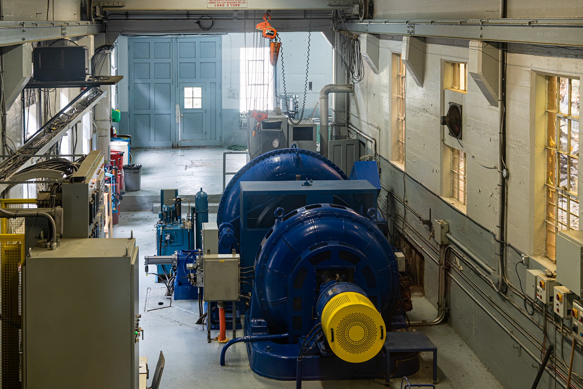 We were visiting the small Parc de la Gorge in Coaticook to view the river and fall foliage when we came upon this small hydroelectric plant. Visitors are allowed to look at the turbine and generator from a balcony.The blue machine is the generating set. The circular volute of the Franics turbine can be seen at the back of the blue machine. It spins a shaft, which turns the generator, which sits closest to the viewer. The generating set is oriented vertically, which is different from the horizontal orientation of larger hydroelectric turbines.Date: 9 October 2018Location: Coaticook, Québec, CanadaOriginal resolution: 36 MPProcessing: Processed from RAW using Adobe Photoshop Lightroom Classic 10