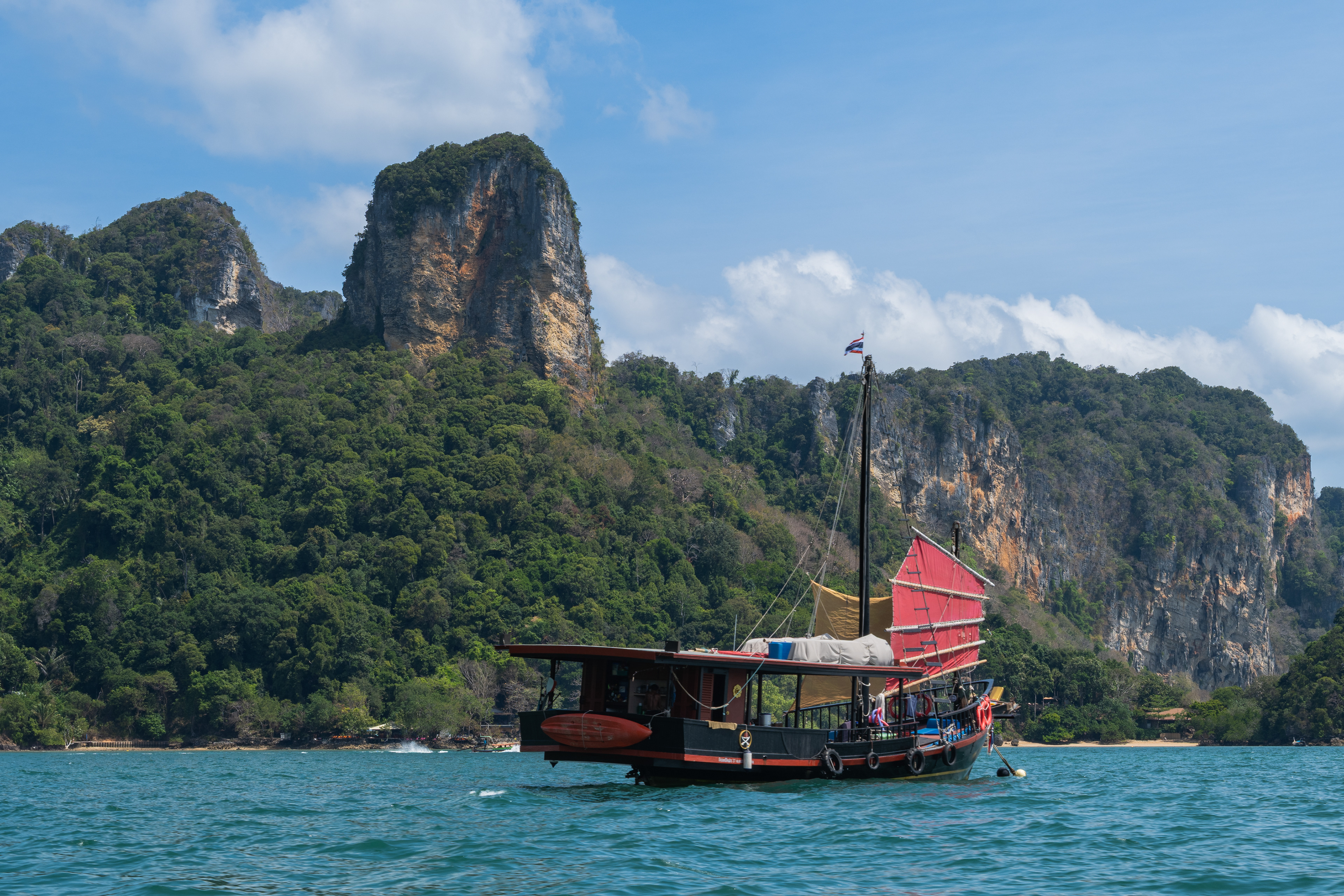 Une jonque moderne quitte la plage de Railay