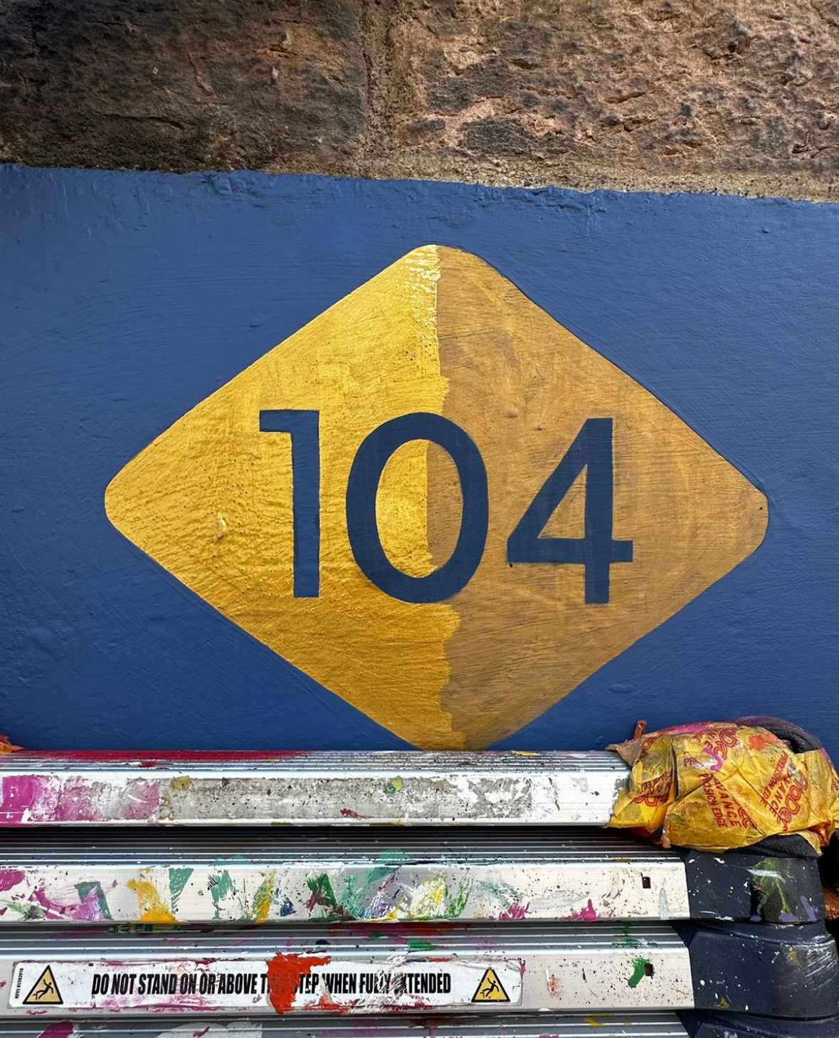 Gold paint after three years' exposure to weather and pollution on a busy street