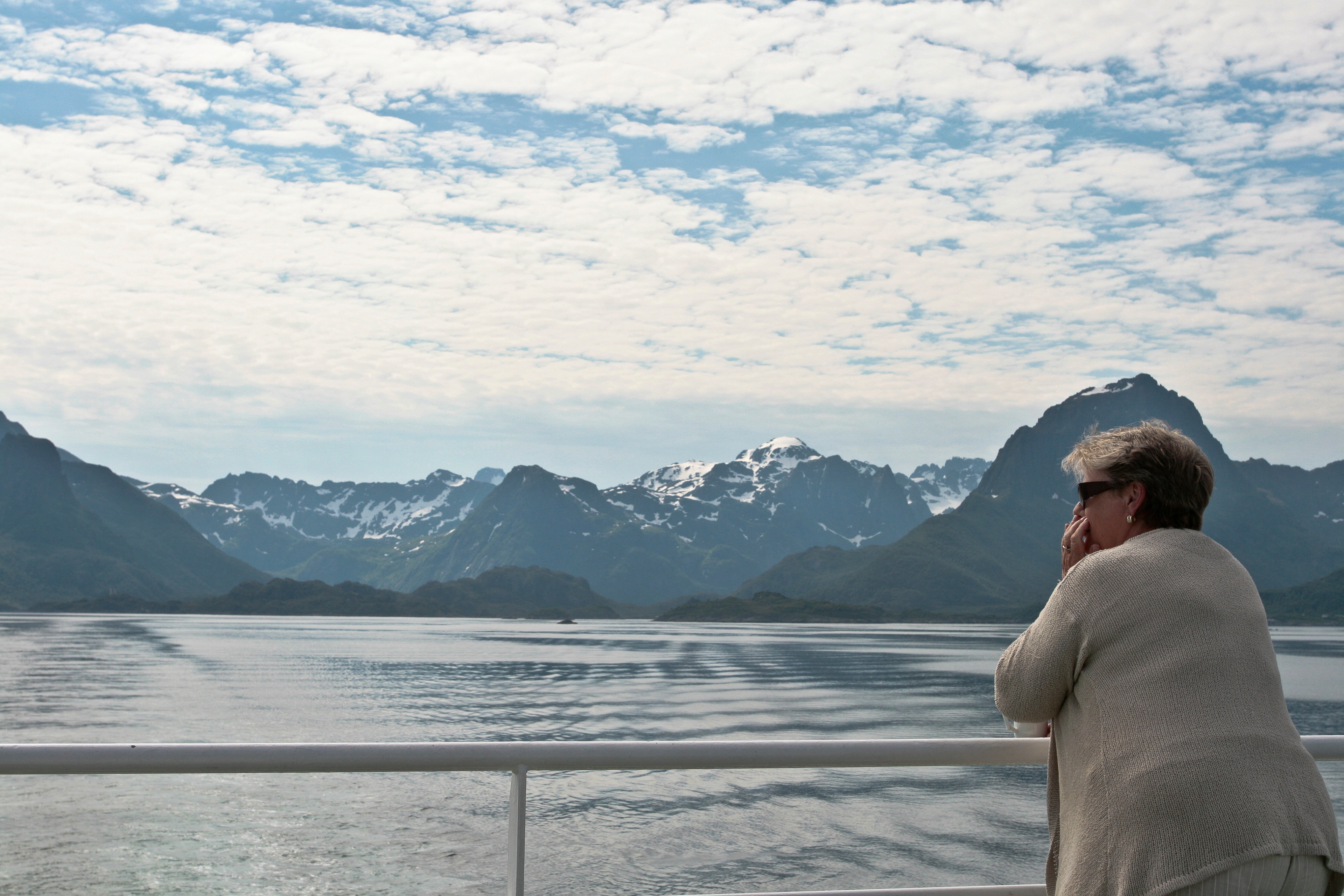 A women looks at the beauty of the Fjords on a ferry boat between the Lofoten island and the mainland, July 2007.