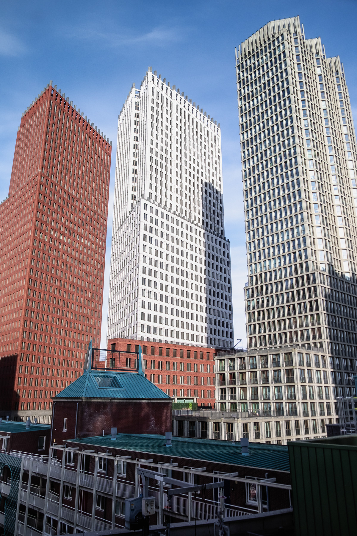 The skyscrapers at Turfmarkt, with on the left the red brick-glad Ministry of Interior Affairs, and in the middle the white, granite-glad Ministry of Justice. April 2025.