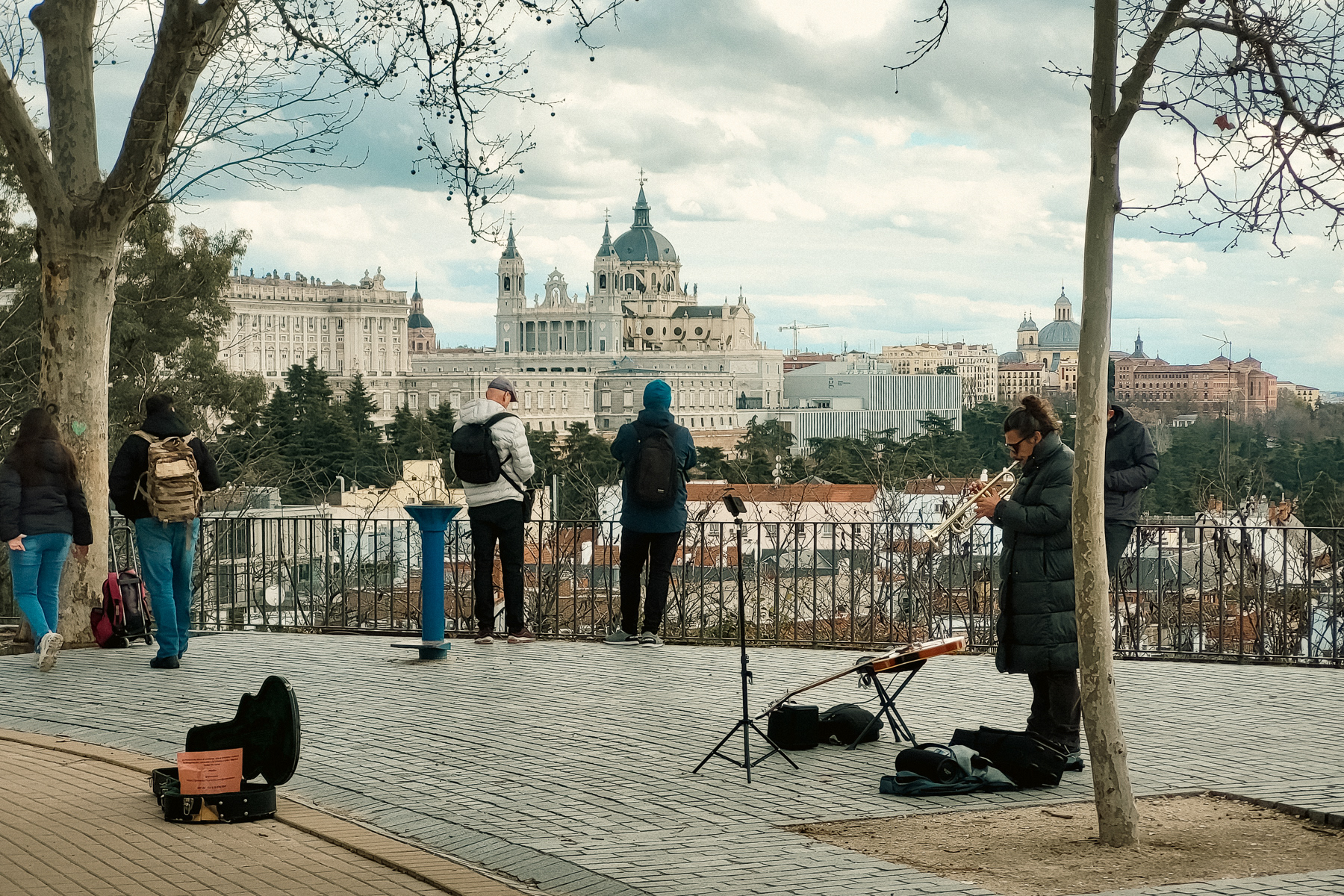 A trumpet / guitar player lights up the viewpoint with music. The Aldmudena Cathedral cannot be missed from here.