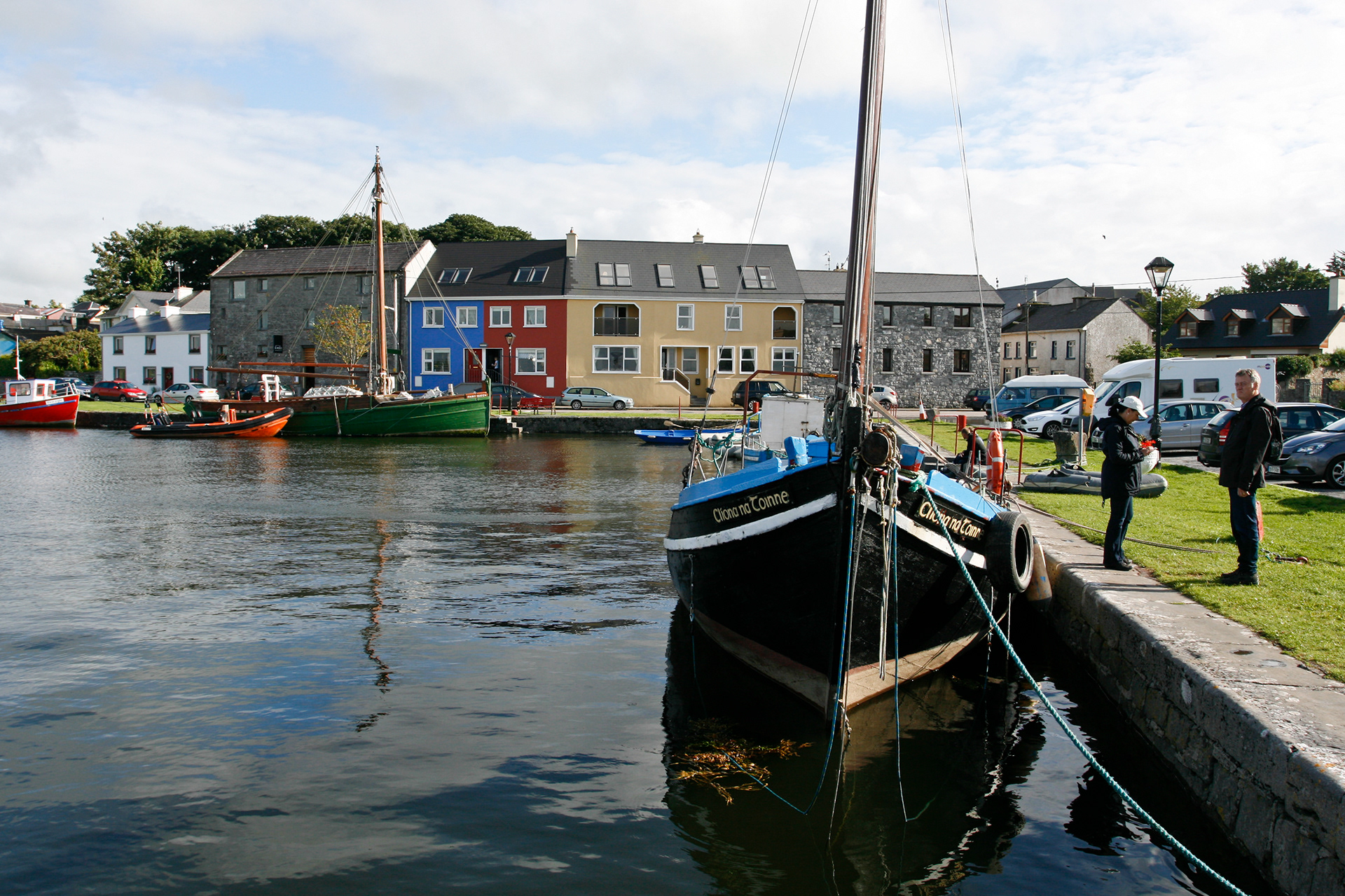 The small harbour of Kinvarra, Ireland, with a few sailing boats against the backdrop of colourful houses.