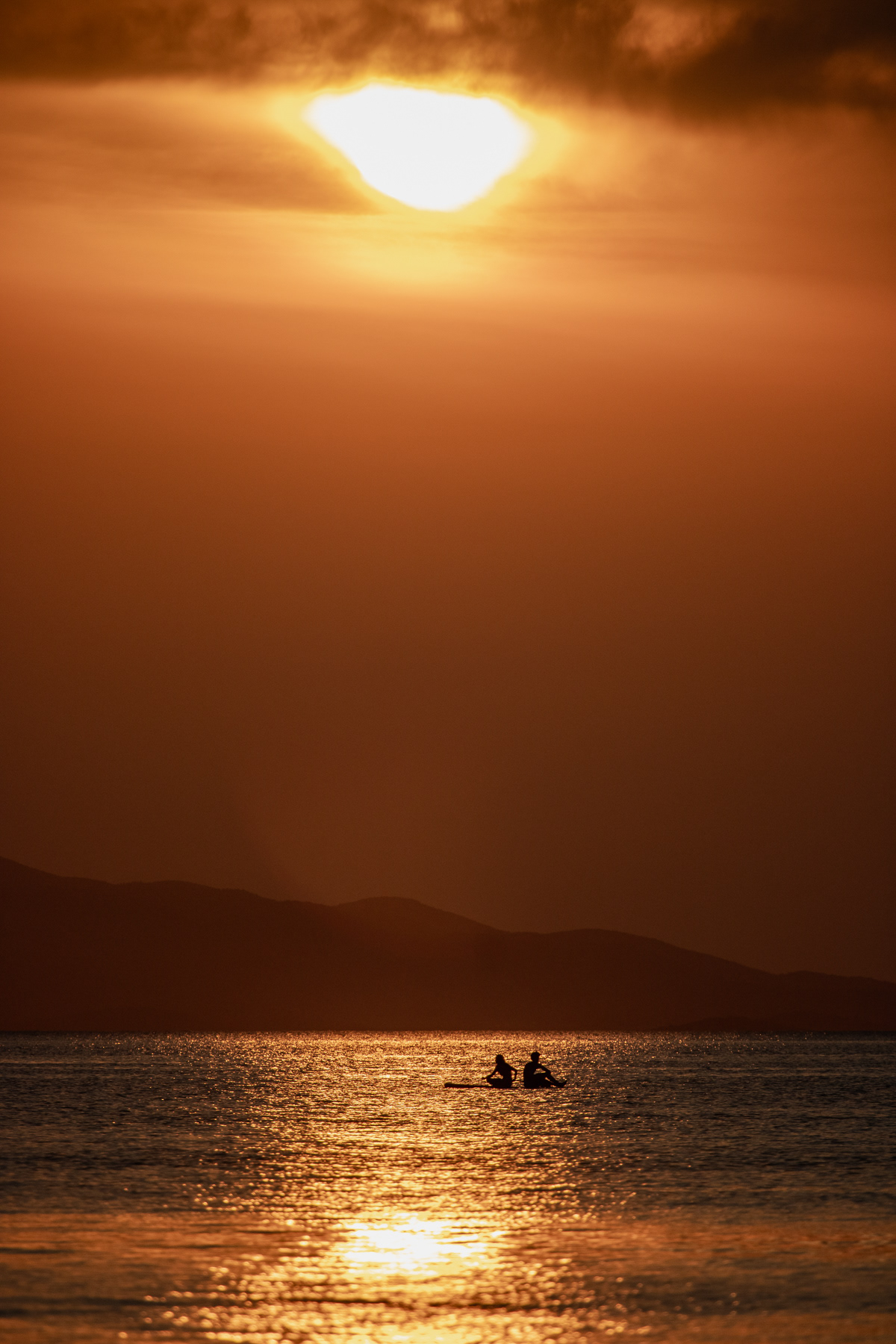 A couple paddles against the backdrop of a crazy sunset, August 2025.