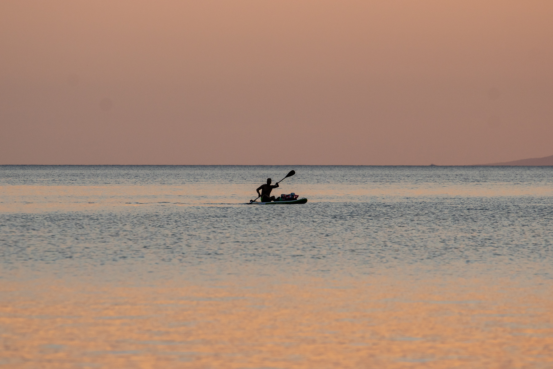 A lone paddler at sea with crazy sunset colours, August 2025.