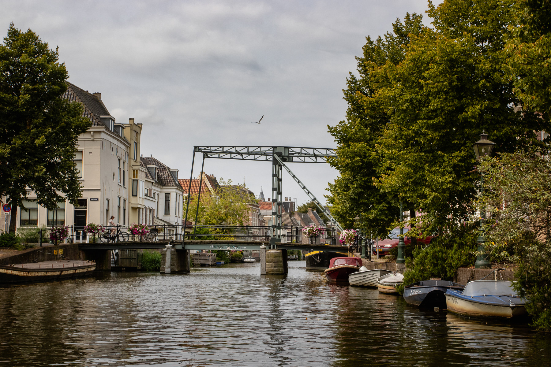 Typical bridge over a canal in Leiden, with boats and a cyclist