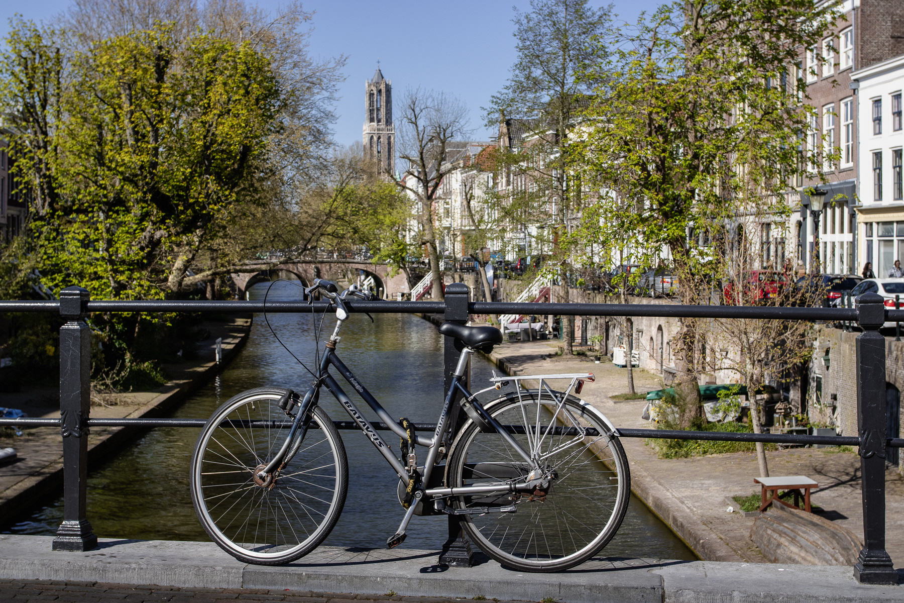 Parked bicycle at an Oudegracht bridge and the Domtoren bell tower