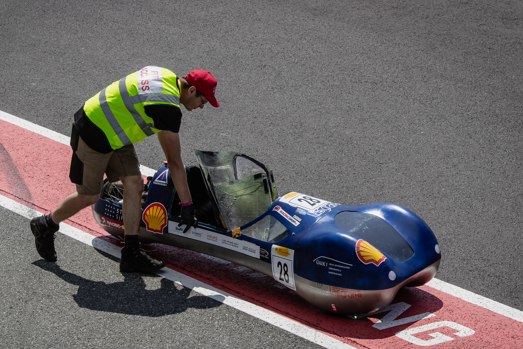 More like a mini-vehicle from Star Wars than a car, being pushed through the pit.