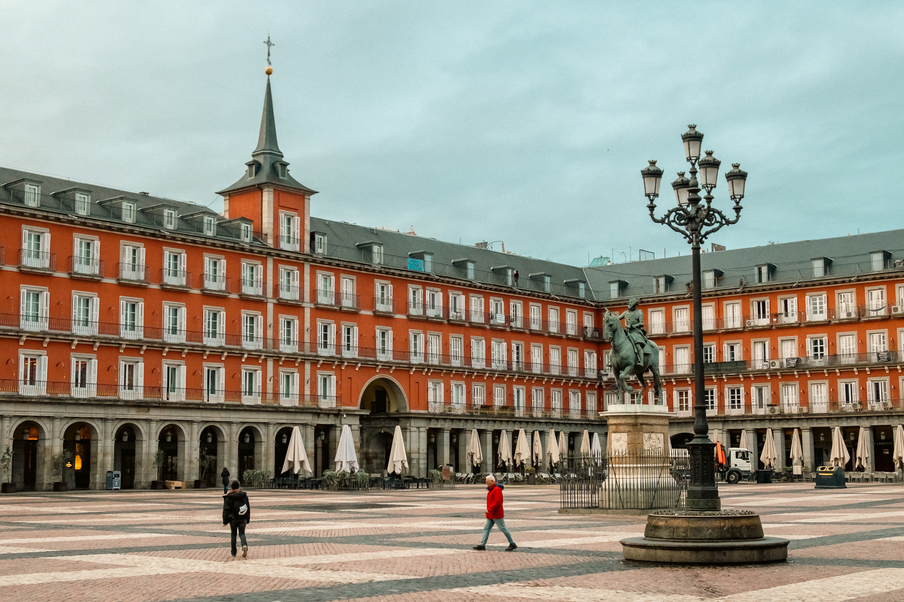 Plaza Mayor in the early morning. The only permanent figure is king Felipe III on a horse (1578 – 1621) who started construction of the first square