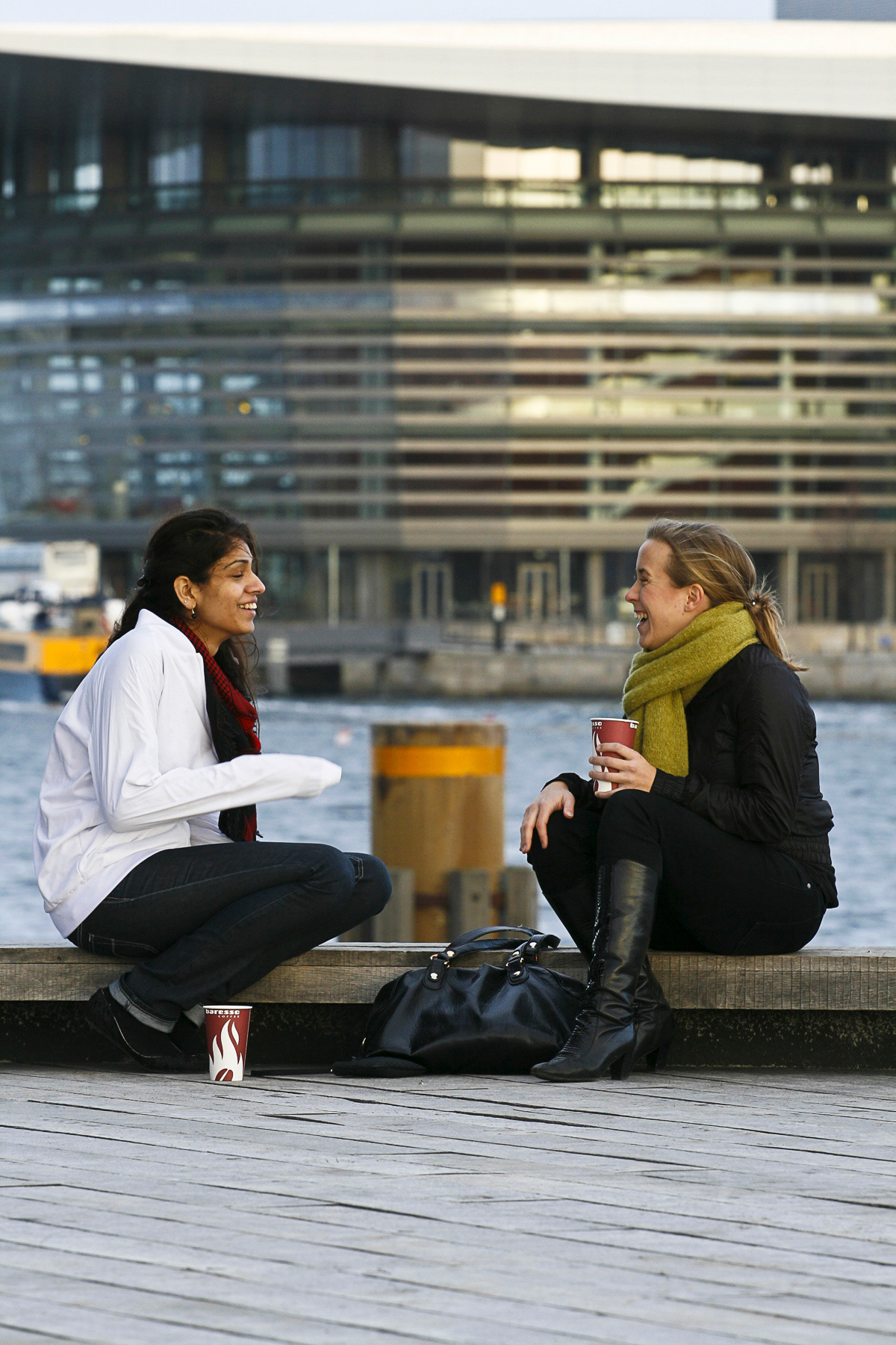 Two young ladies chatting, with the Opera in the backdrop