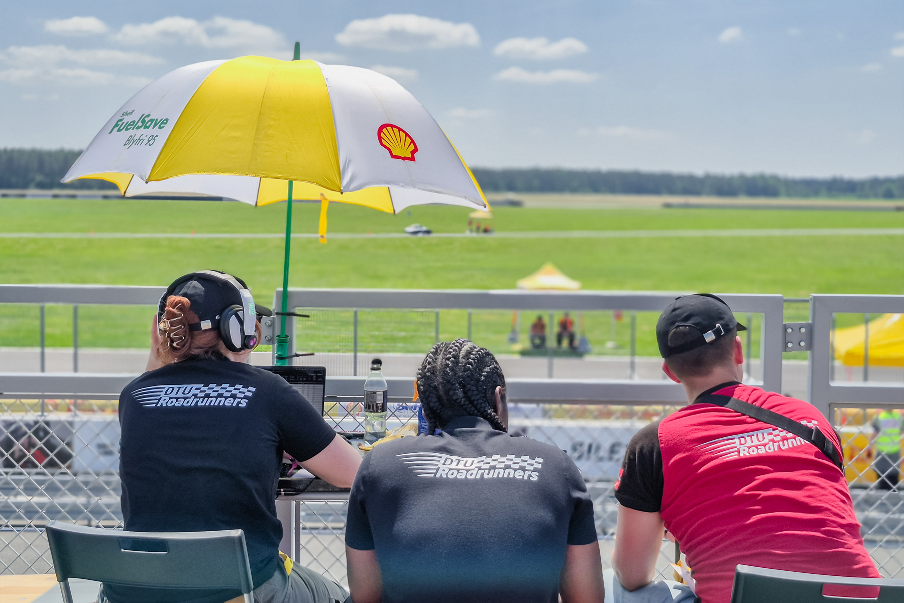 The ground crew of the Danish Technical University is monitoring the progress of its vehicle while it completes multiple rounds on the track.