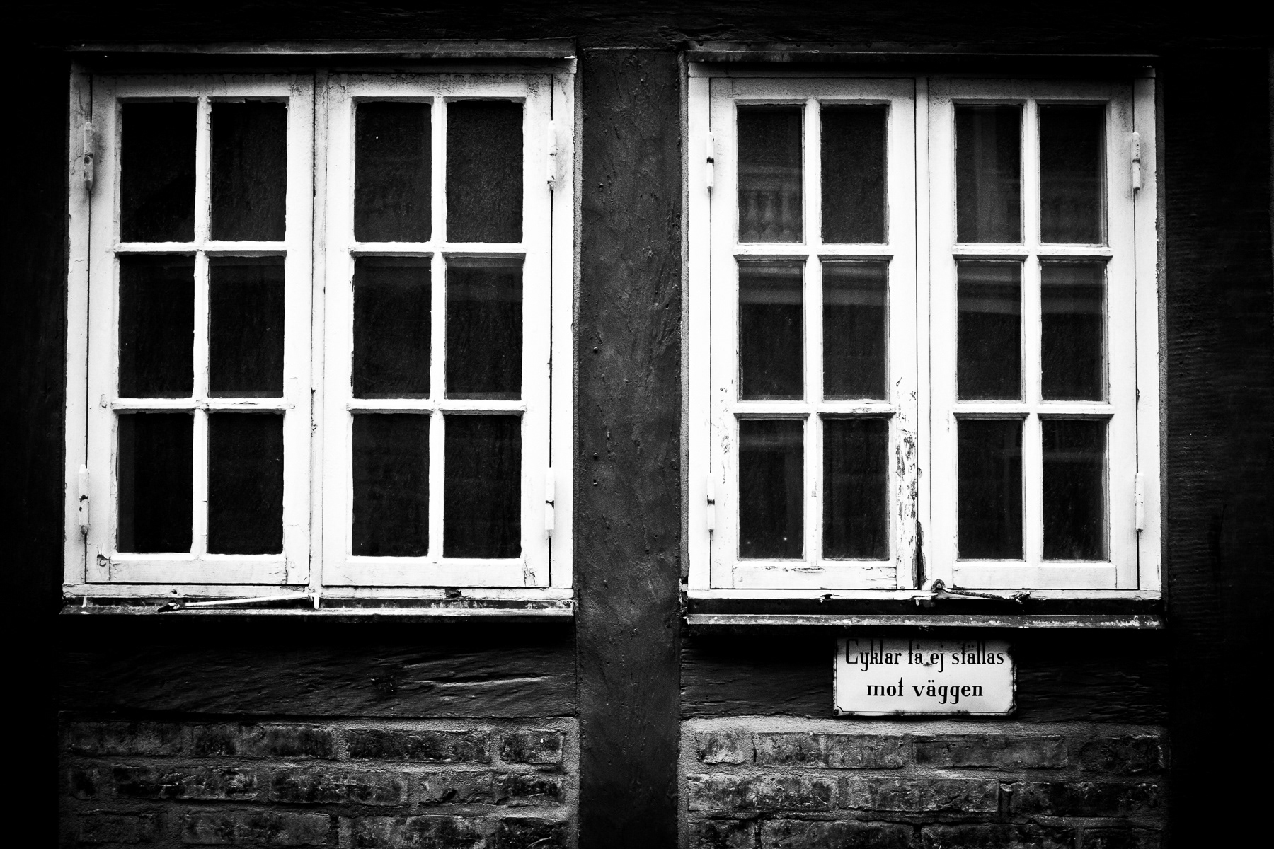 Old windows in Helsingborg's Old Town. The sign reads: "Bicycles are not allowed to be left against the wall"