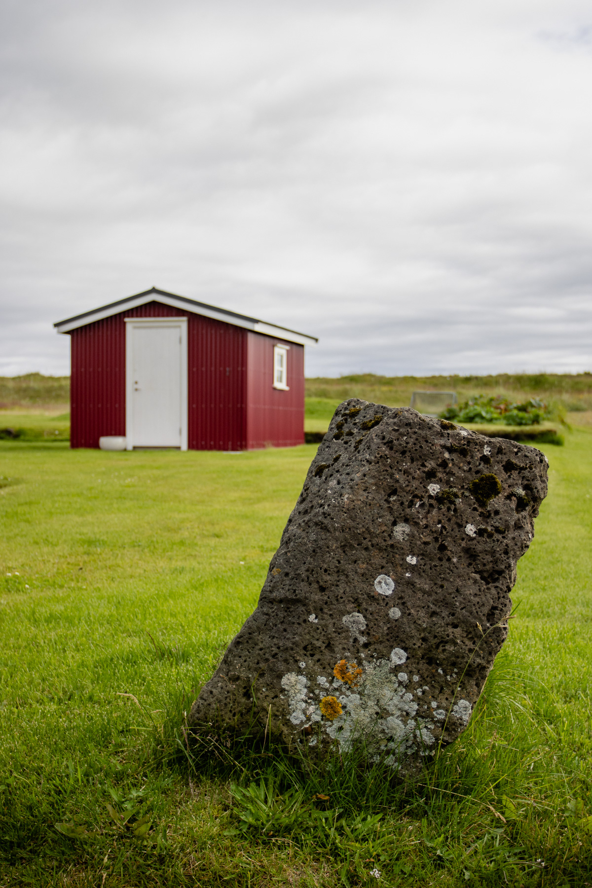 A tilted stone and a red cabin in Eyrarbakki