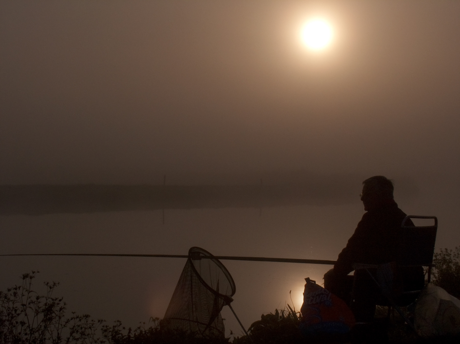 A lone fisherman at a canal just outside Schipluiden, October 2003.