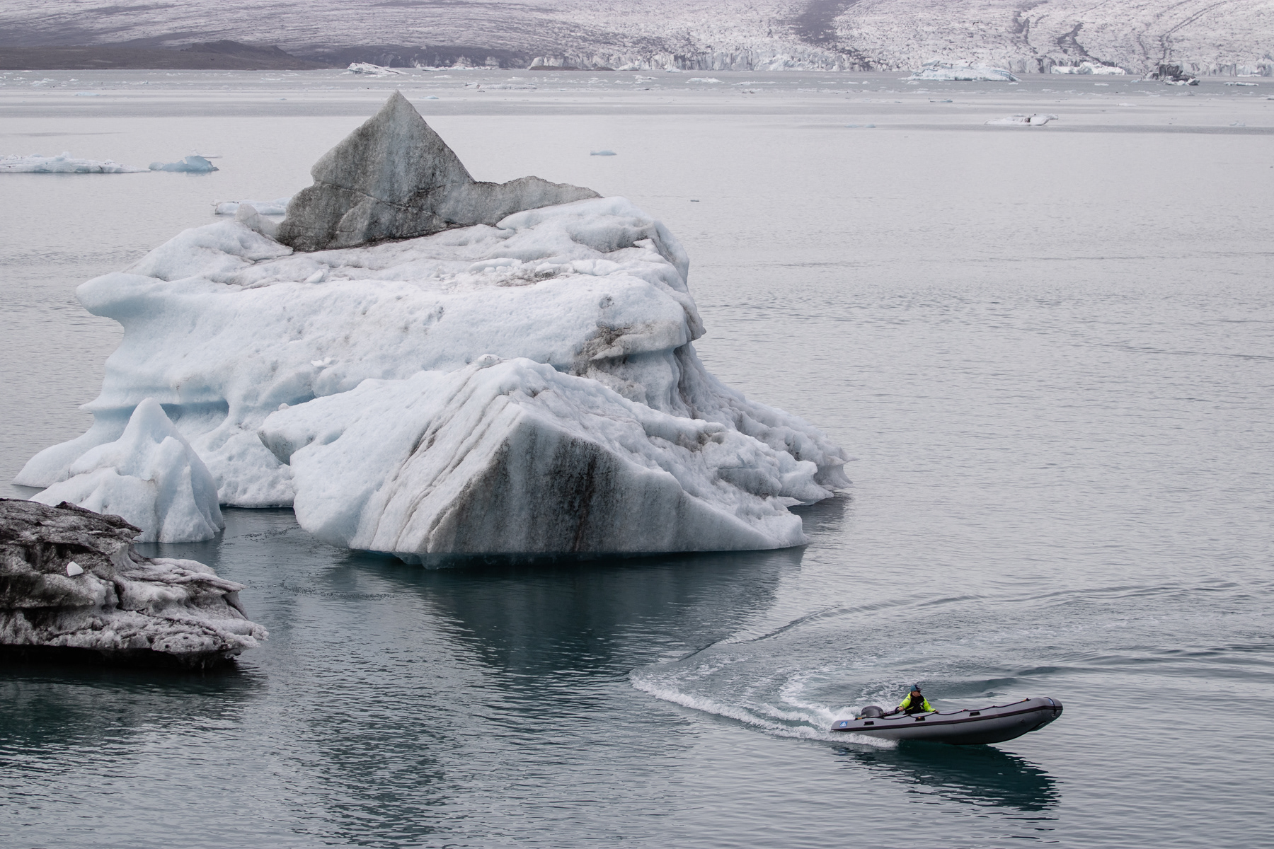 A rib with one safety employee cruising through the glacier lake.