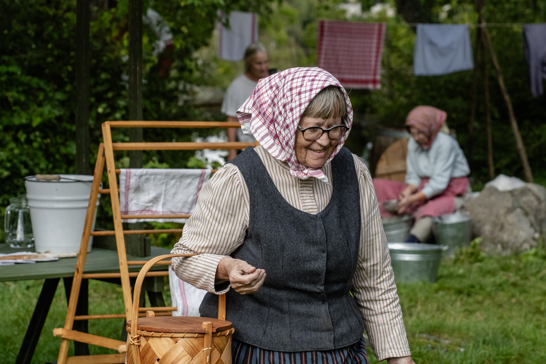 A lady in character of the 1800s with a basket on her arm.