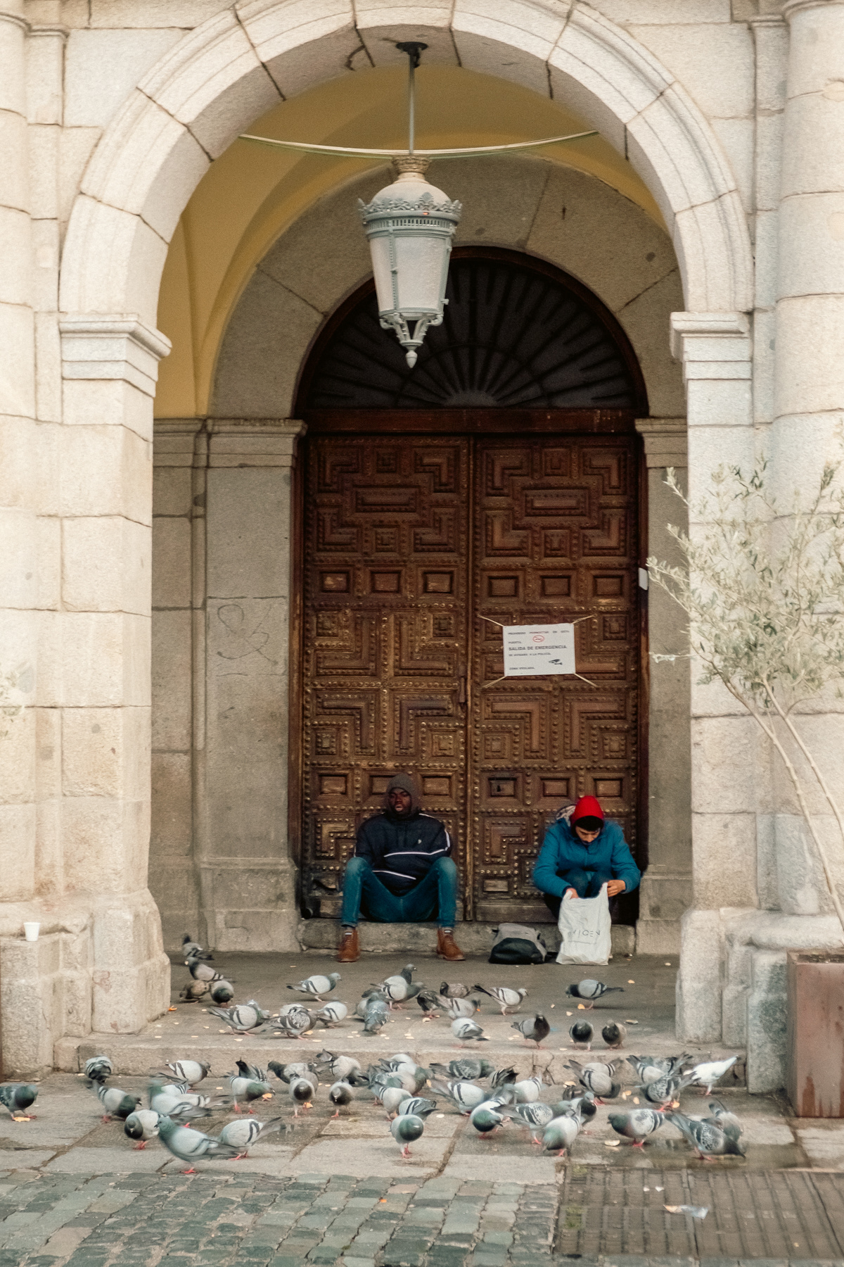 In the early morning you'll find some pigeons and homeless underneath the arched walkways of the square