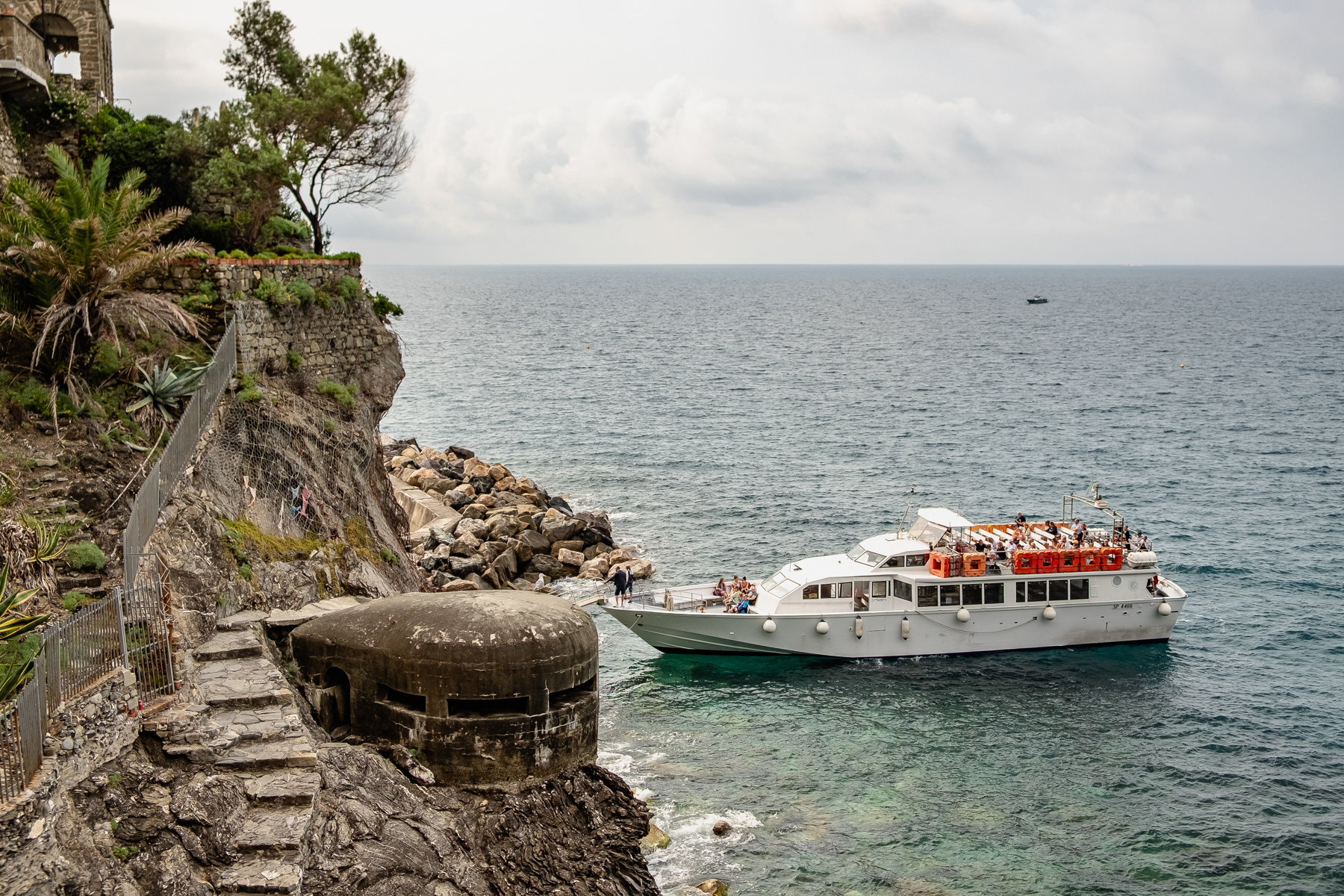 A tour boat moars near an old military fortification.