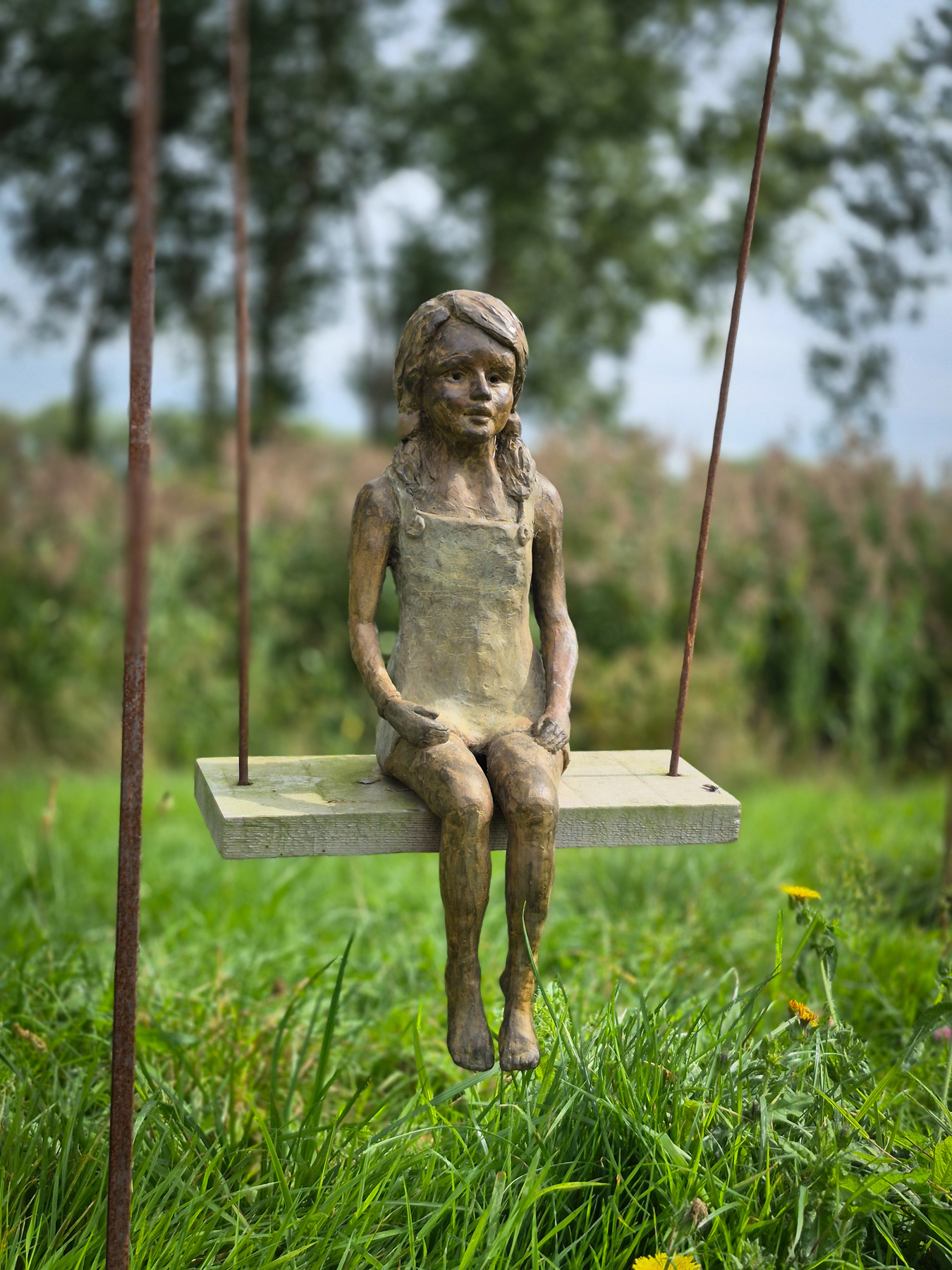 Statue of a girl on a swing.