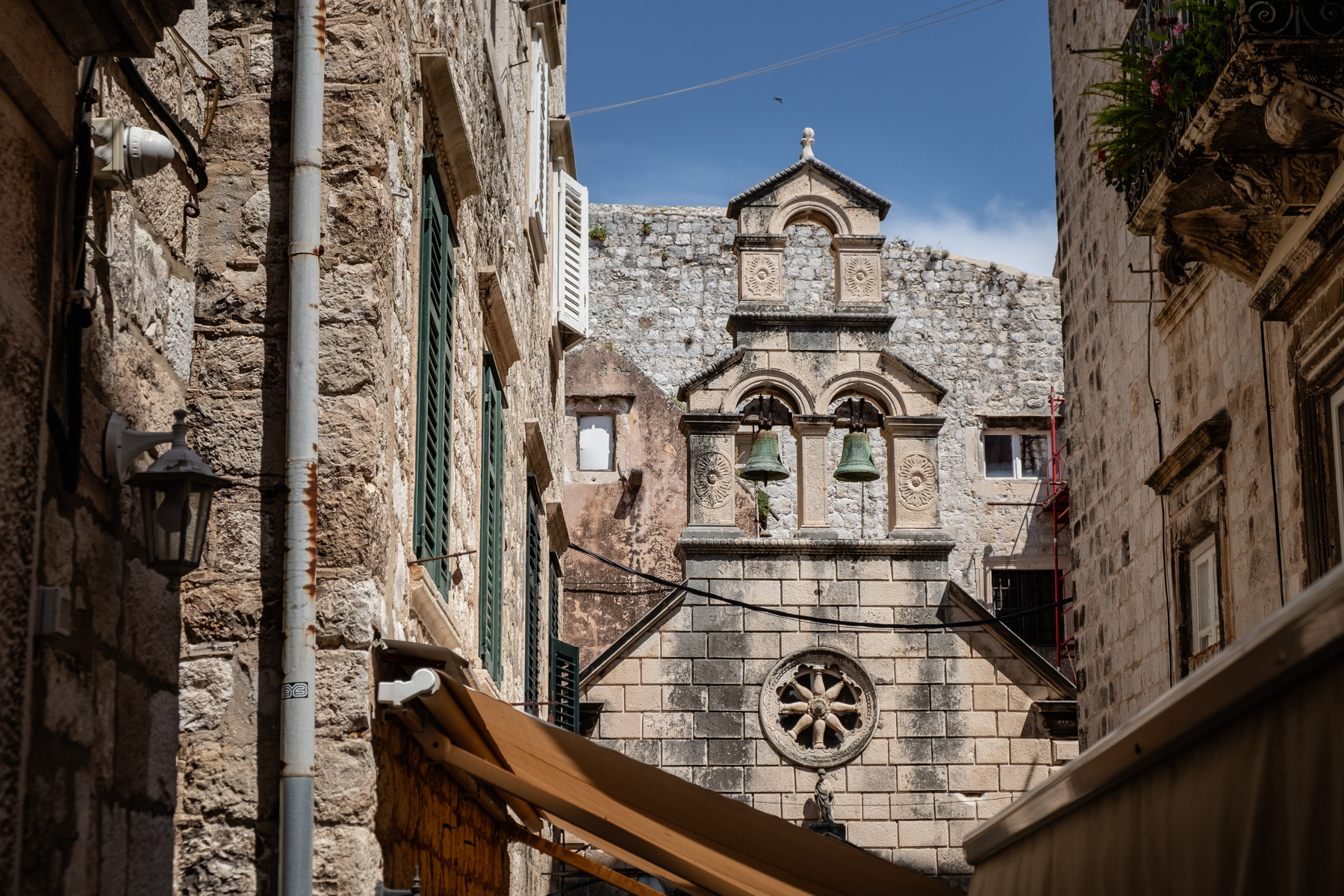 A church's bell tower in an alley, July 2023.