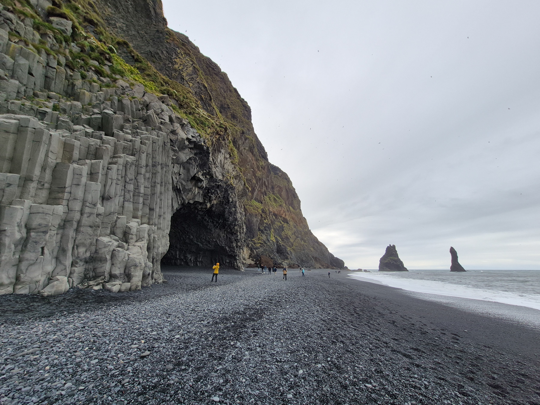 Reynisfara Black Beach with the famous Reynisdrangar rocks out at see, the basalt stone columns, and the Hálsanefshellir Cave.