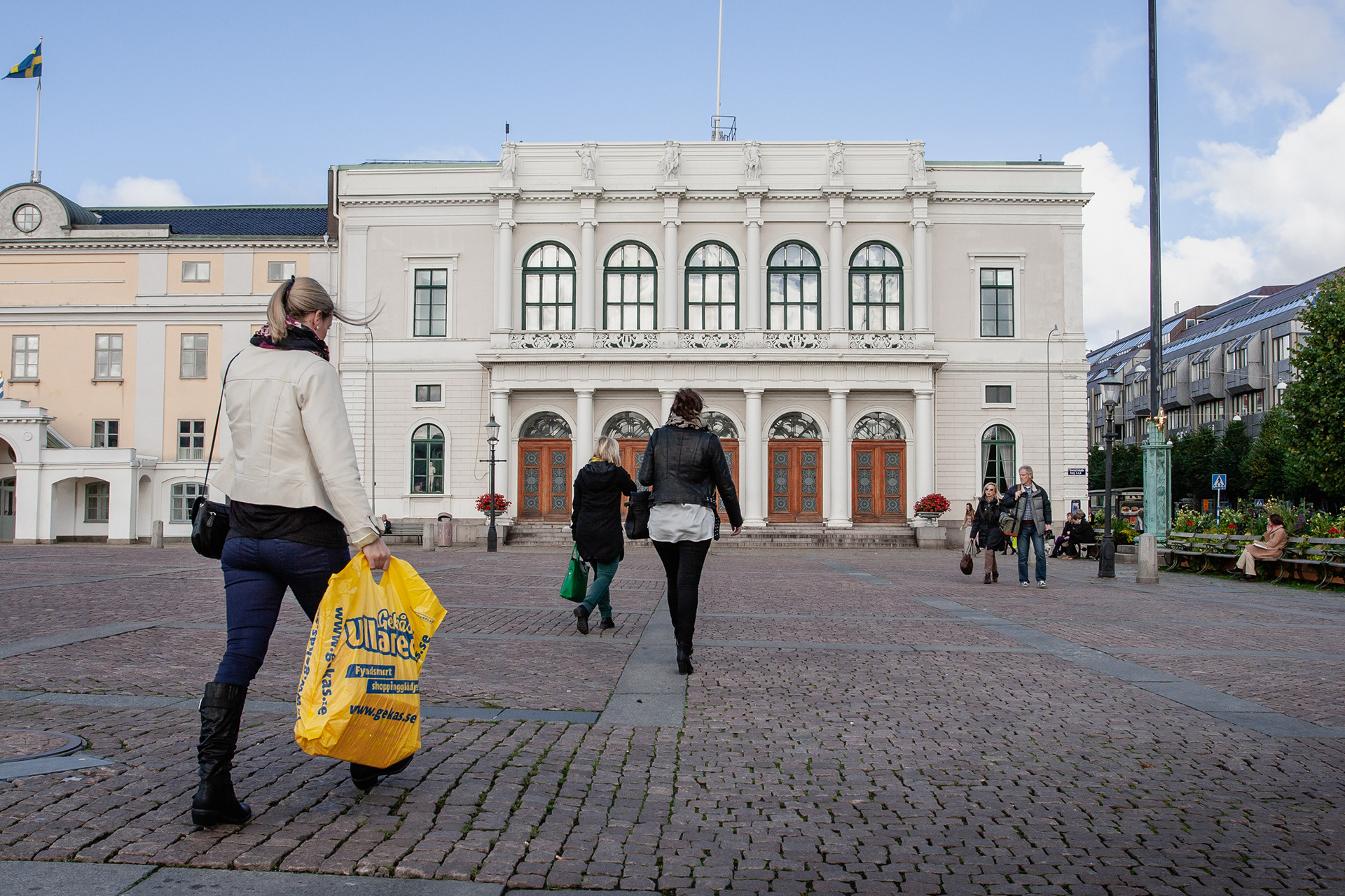 The white building on the corner with Östra Hamngatan is the old trad house, Börsen or Börshuset, and dates from 1849. Six sculptures symbolizing Gothenburg adorn the facade: craftsmanship, happiness, trade, shipping, wealth, and industry. Photo taken in October 2012.