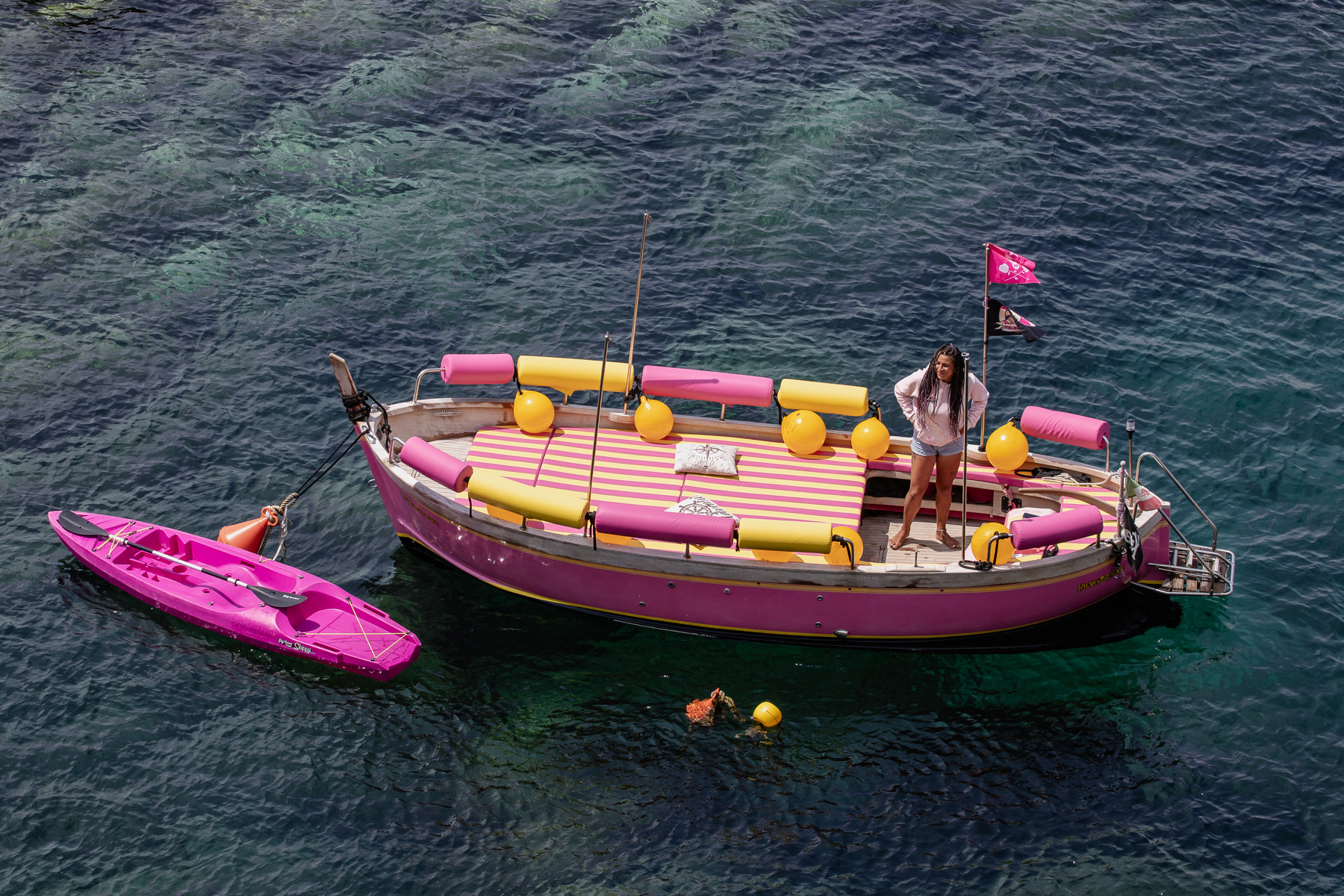 A yellow and pink tourist boat waiting in the harbour of Riomaggiore.