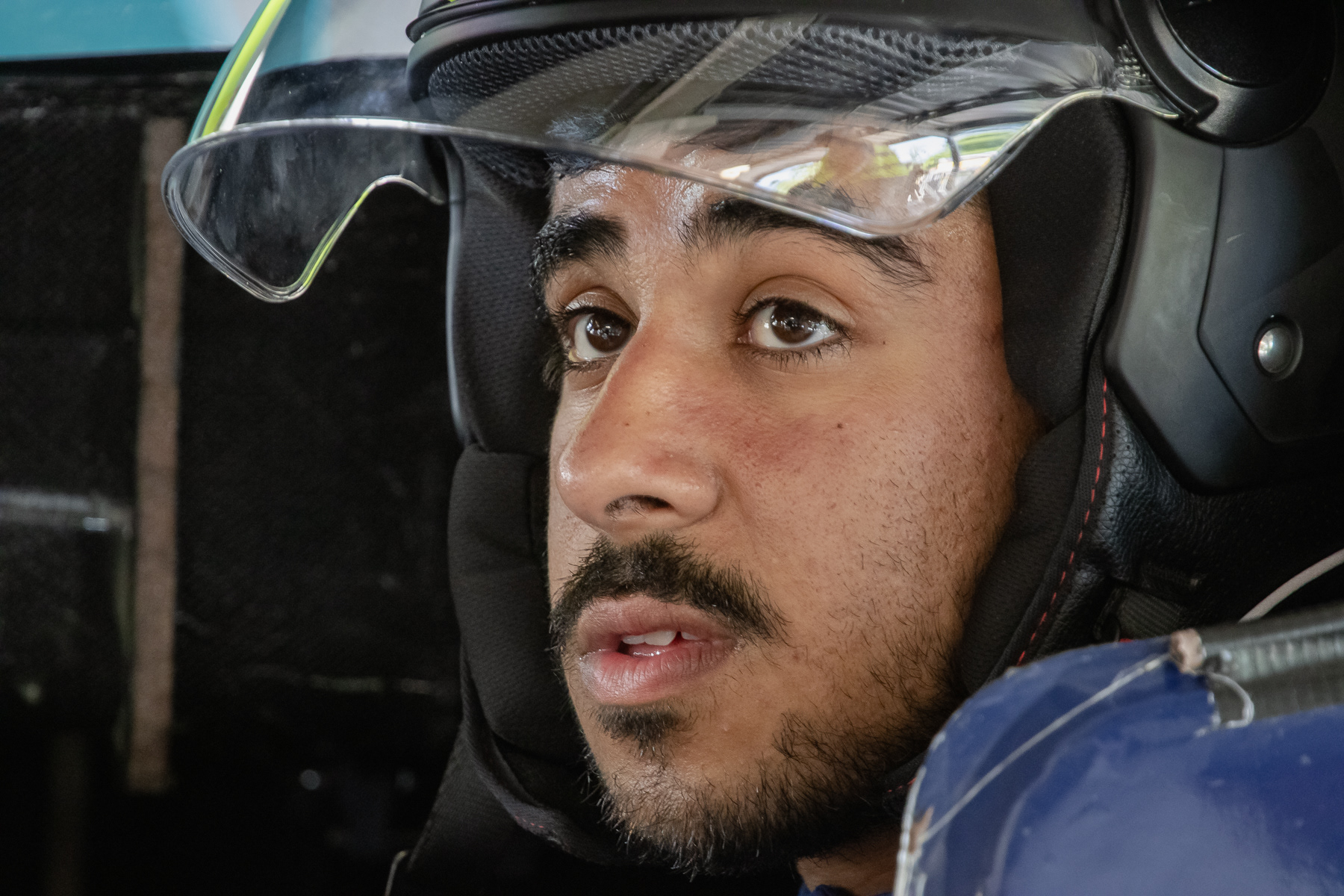 Tension and concentration on the face of this male driver, at final pre-race checks.
