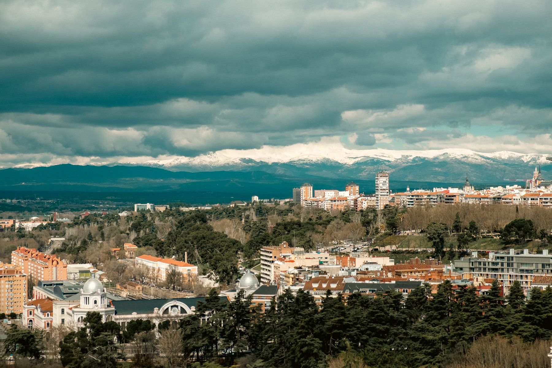 View to the north from the rooftop terrace of the Almudena Cathedral. Notice the snowy mountains seen in mid-March. The shiny silver towers are part of the Príncipe Pío railway station.