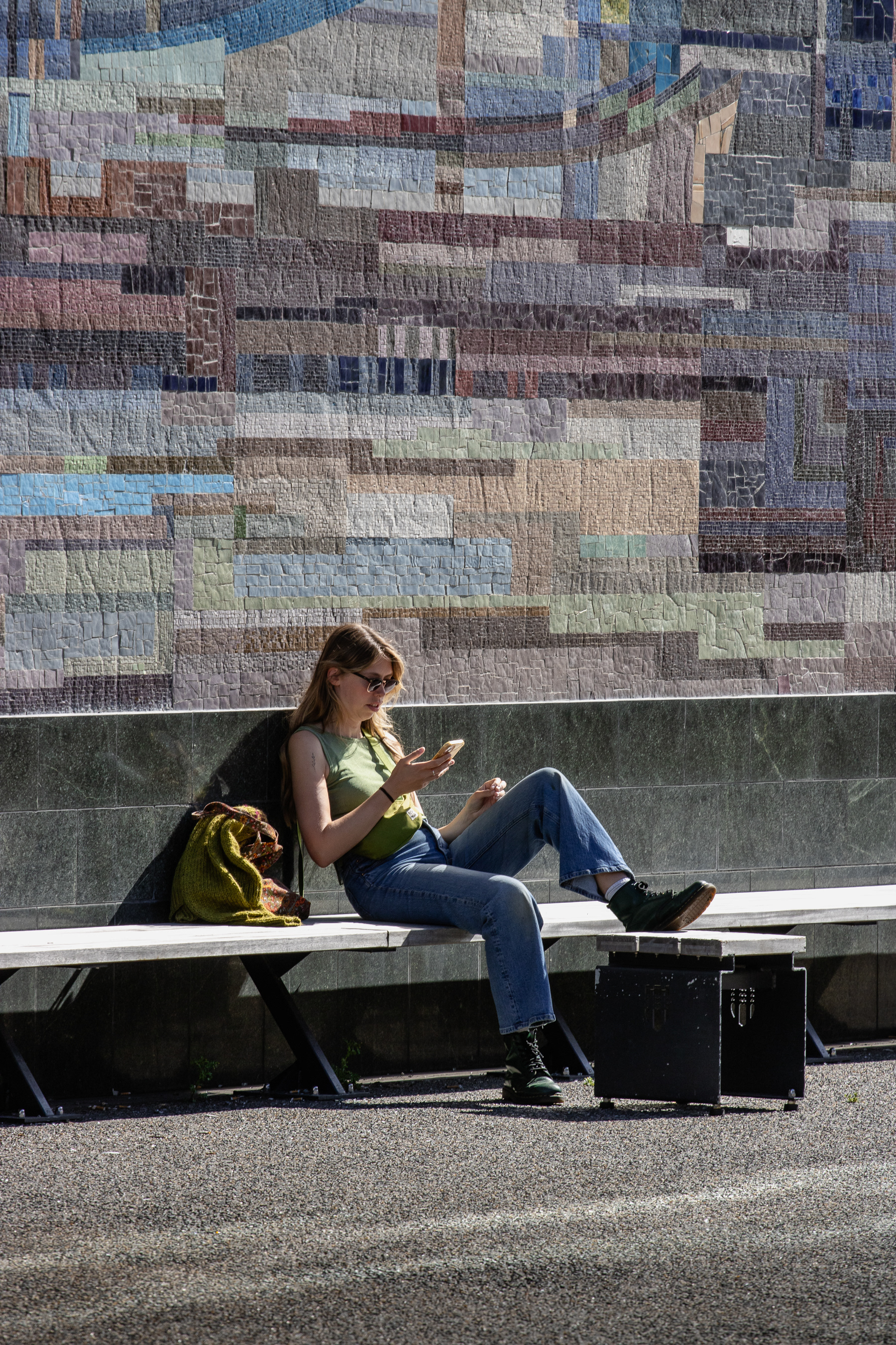 A young woman taking a break at the Mósaík by Gerður Helgadóttir in Tryggvagata.
