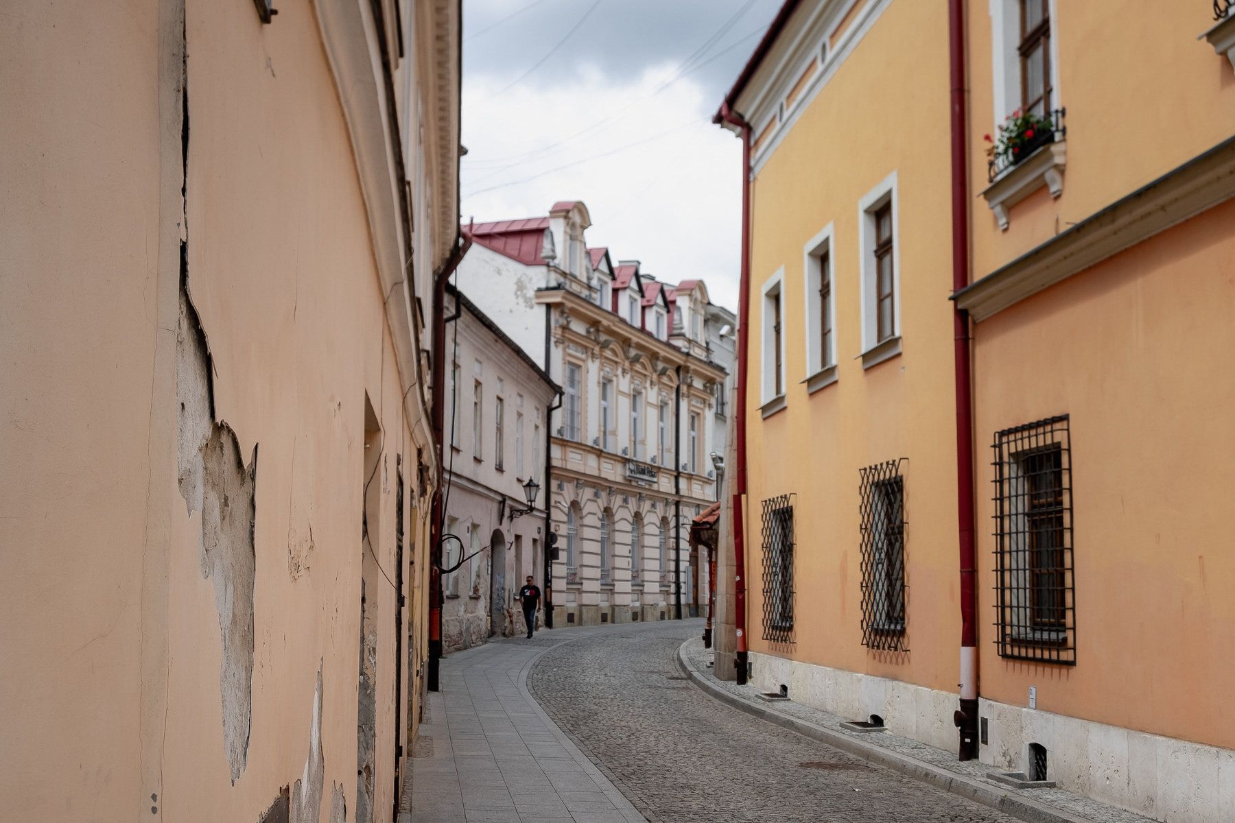 A curved street in the Tarnów centre, with a pedestrian on the sidewalk