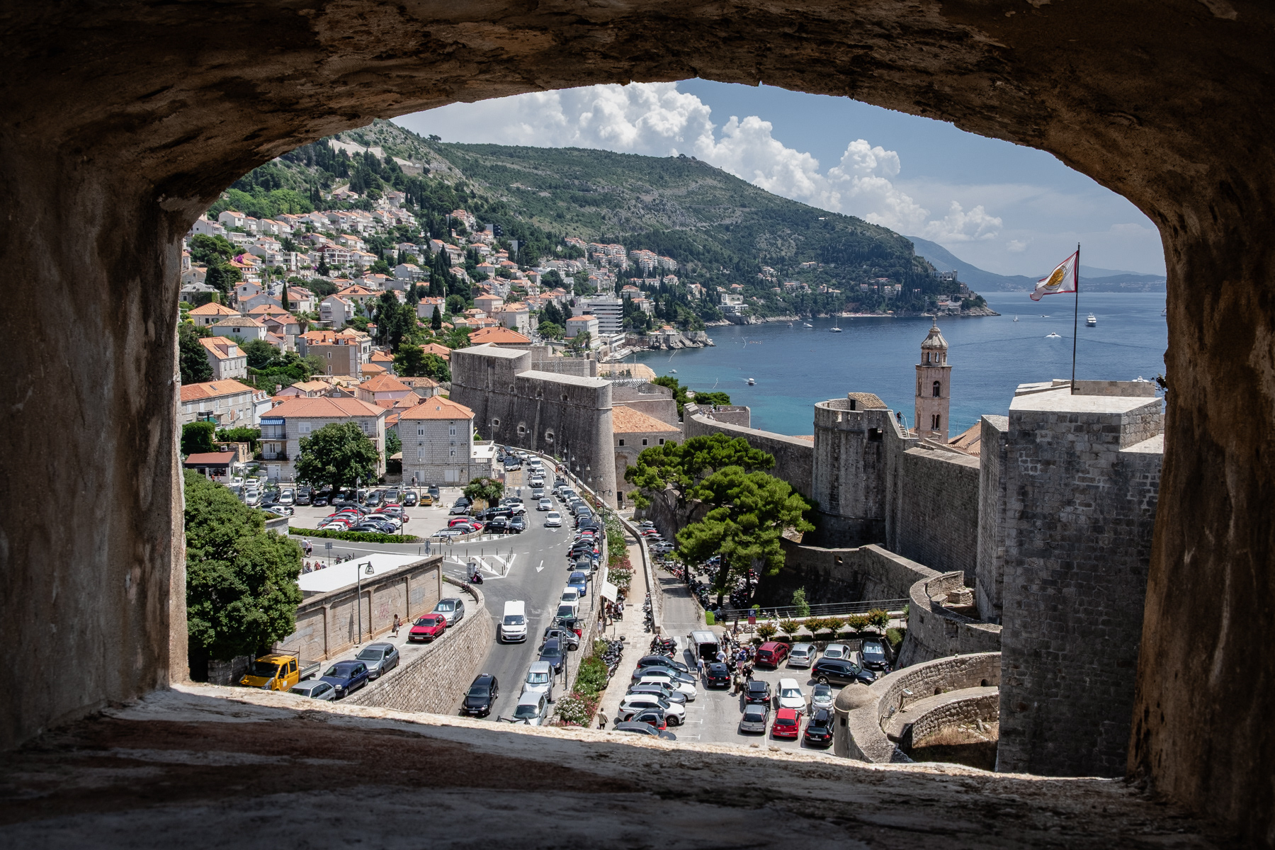 View to the southern outskirts of Dubrovnik through one of its defence towers, July 2023.