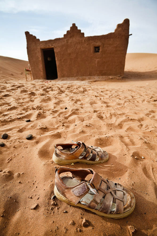 Sandals in front of a house in Sahara desert in Morocco. Vertical shot.