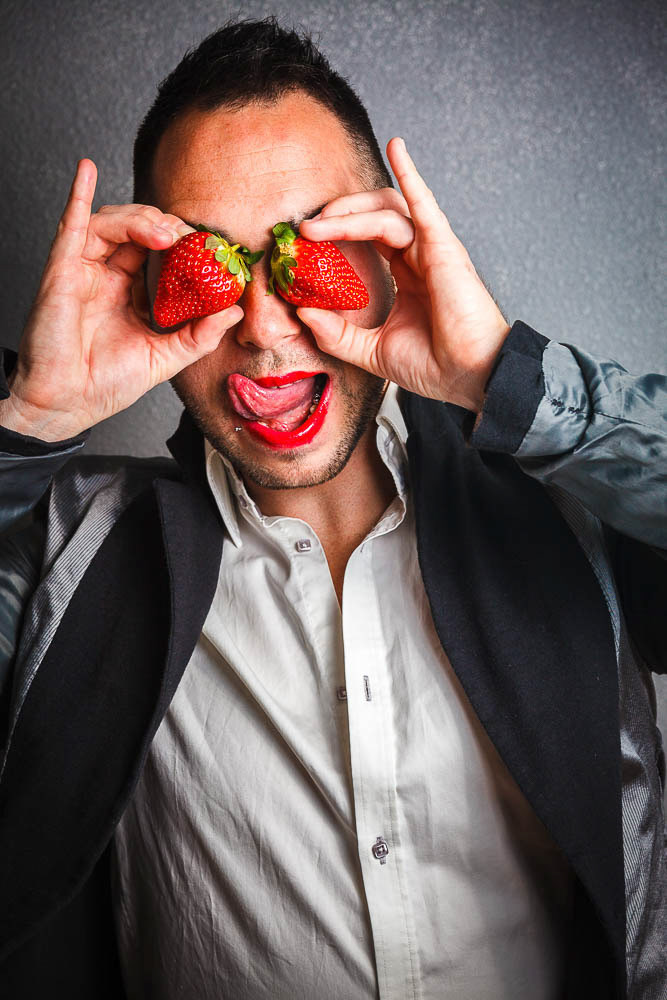 Young man in jacket with strawberries in the eyes.