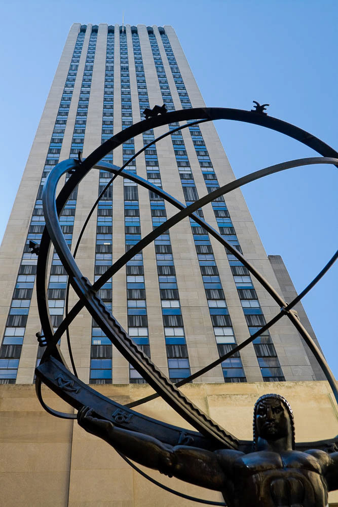 Iron statue of a man in front of the Rochfeller center.