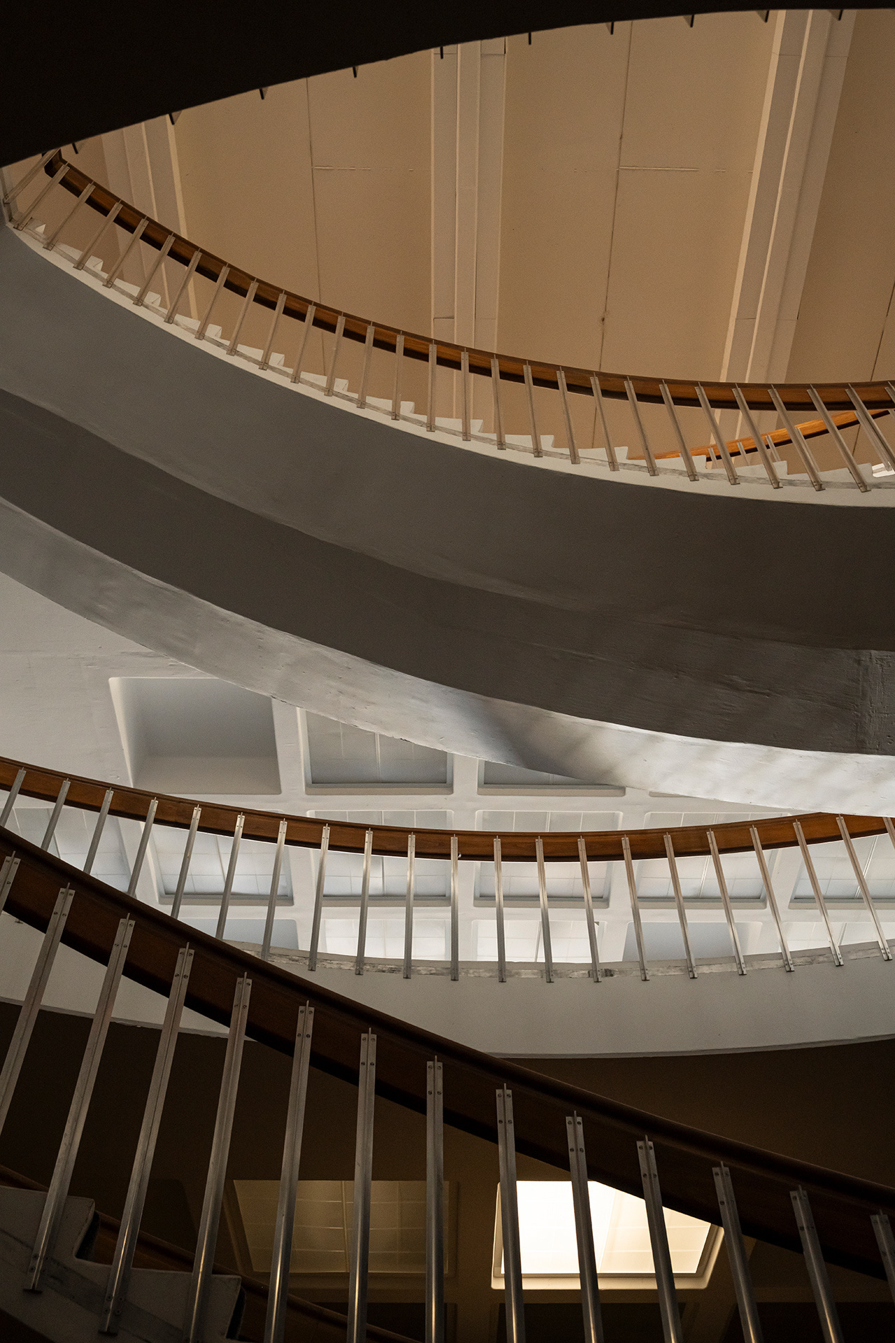 Looking through the layers of the spiral staircase at Fogelson Library with rich shadows and subdued daylight