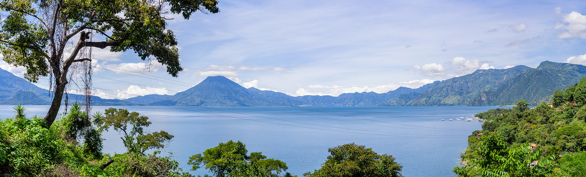 A view of the cerulean windswept waters of Lago de Atitlan looking towards Volcan de San Pedro and the lush green of the hills framing the lake and the sky