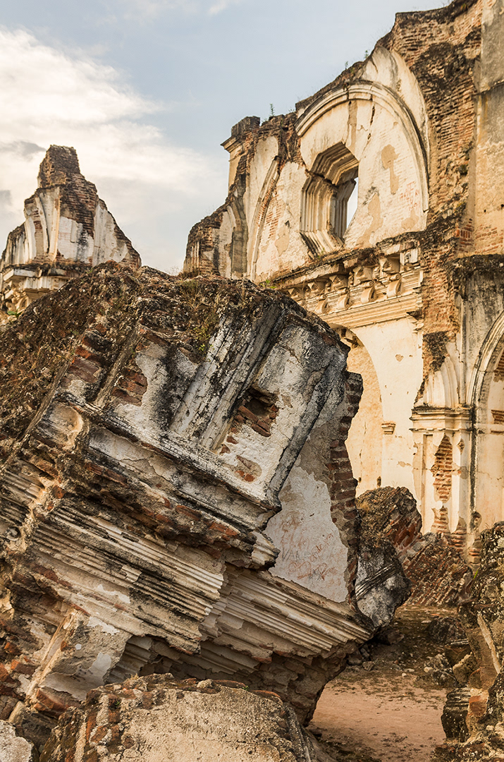 The ruins of a large brick and white plaster wall catching the orange rays of sunset