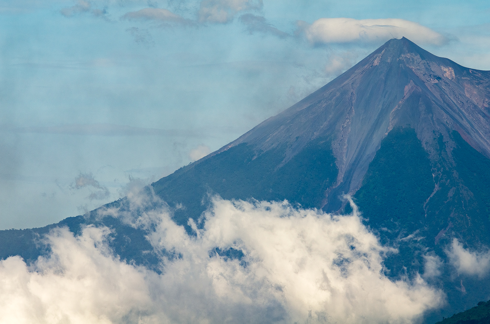 looking through the humid atmosphere at the volcanic summit of Volcan de Agua, from a vantage point on Volcan de Pacaya