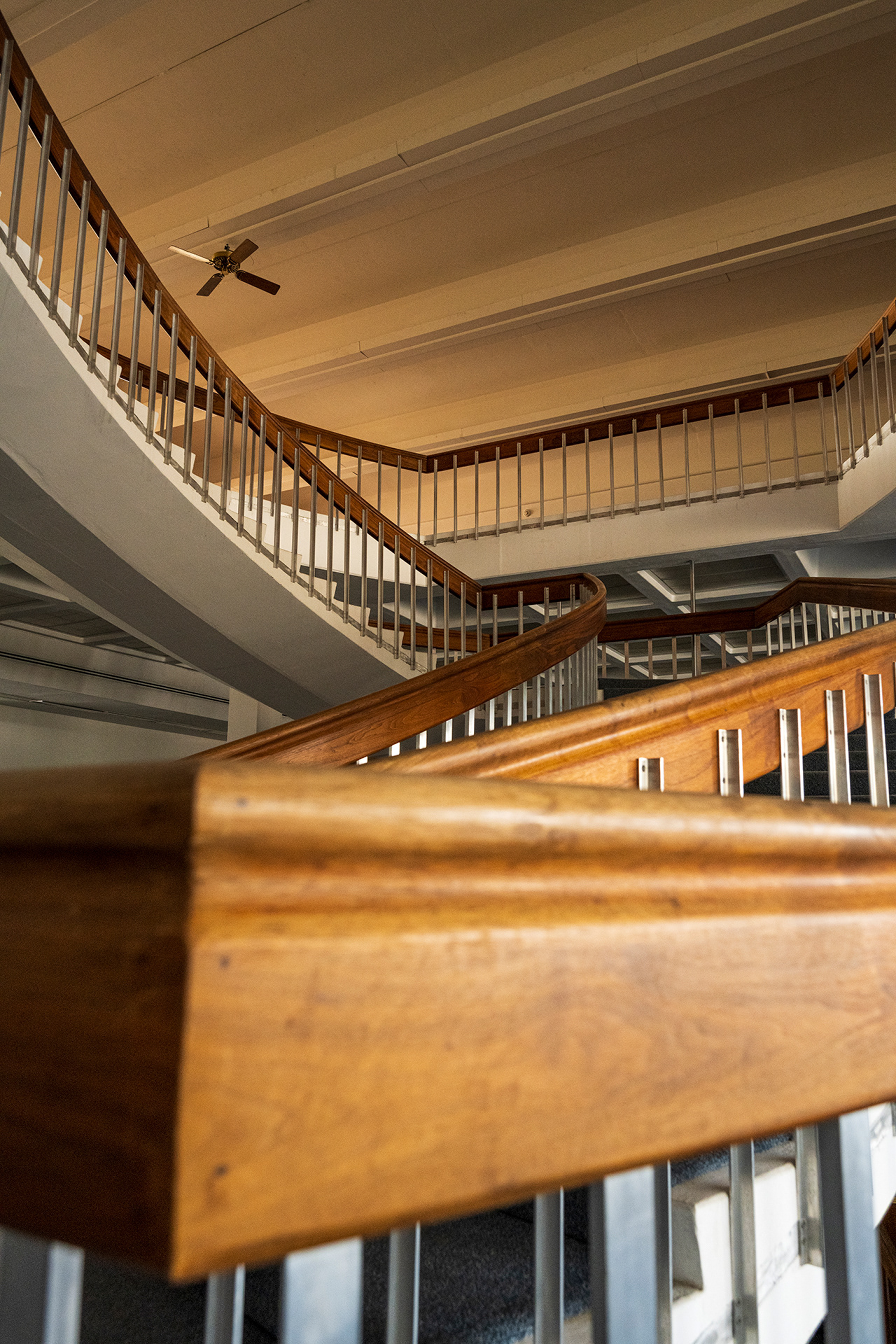 Visually following the balustrades of warm walnut and white aluminum along a sweeping curve. 